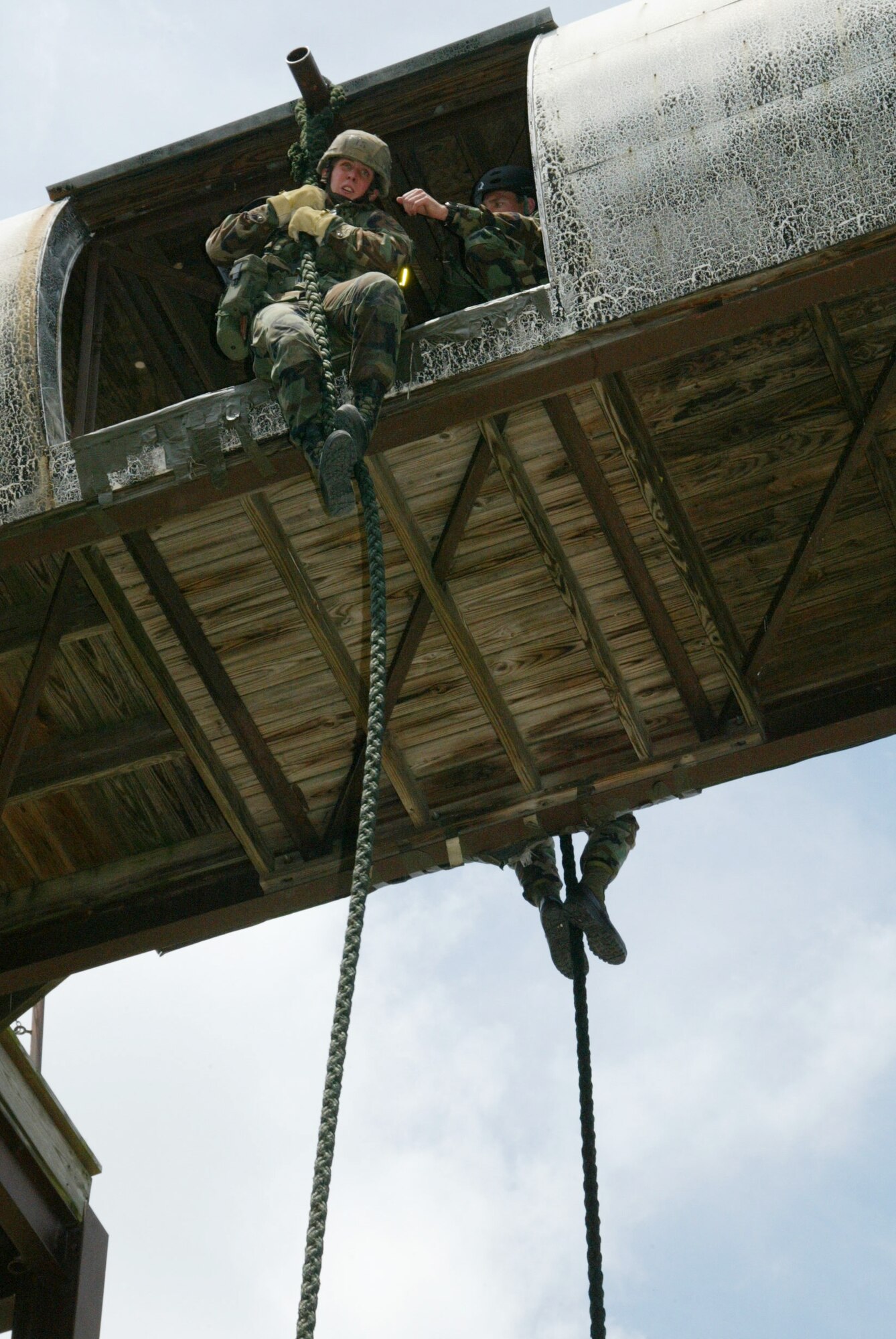 Airman Joshua Mattert, 342nd Training Squadron, begins to fast rope from the Combat Control School tower Tuesday, April 11, at Pope Air Force Base, N.C. Combat control trainees spend a full day learning the details required to fast rope, rappelling and climbing a caving ladder. In the operational world combat controllers would fast rope out of helicopters in urban environments where helicopters would not be able to land. The trainees fast roped from 10, 20 and 30 feet, before they progressed to the tower which is 40 feet above ground. (U.S. Air Force photo/Staff Sgt. Becky J. LaRaia) 