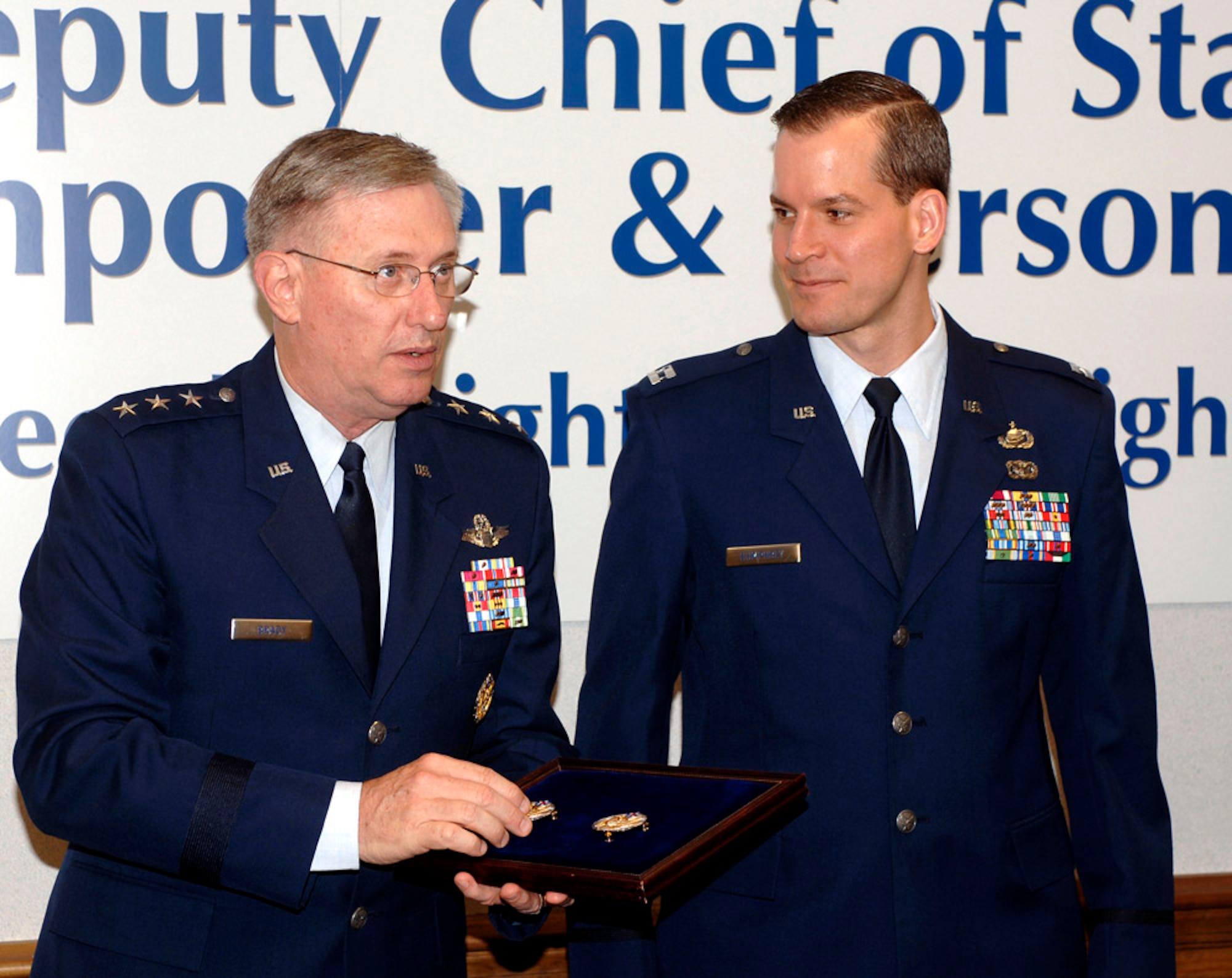 Lt. Gen. Roger Brady, deputy chief of staff for manpower and personnel, prepares to present the new Headquarters Air Force badge to Capt. Brian Humphrey during a ceremony marking the official release of the badge on Friday, May 19, 2006, in the Pentagon.  Airmen assigned to the Pentagon will have the option to wear the new badge.  The basis for the badge is Air Force heritage and the design incorporates many elements from the Department of the Air Force Seal.  Air Force Chief of Staff Gen. T. Michael Moseley approved the design and development of the badge in September.  (U.S. Air Force photo/Tech. Sgt. Scott M. Ash)