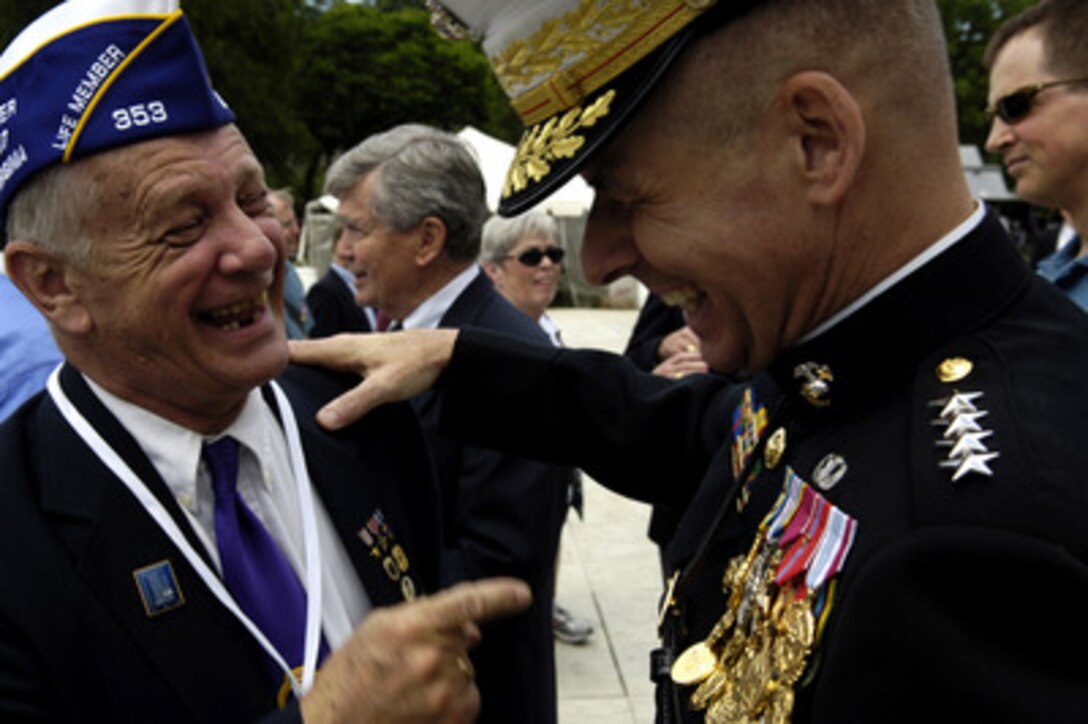 Chairman of the Joint Chiefs of Staff Gen. Peter Pace, U.S. Marine Corps, shares a laugh with a Korean War veteran after the "A Time of Remembrance" ceremony held on the grounds of the Washington Monument in Washington, D.C., on May 21, 2006. The first-of-its-kind event is for family members of armed forces personnel killed in Afghanistan and Iraq as well as descendants of American heroes from every war dating back to 1776. 