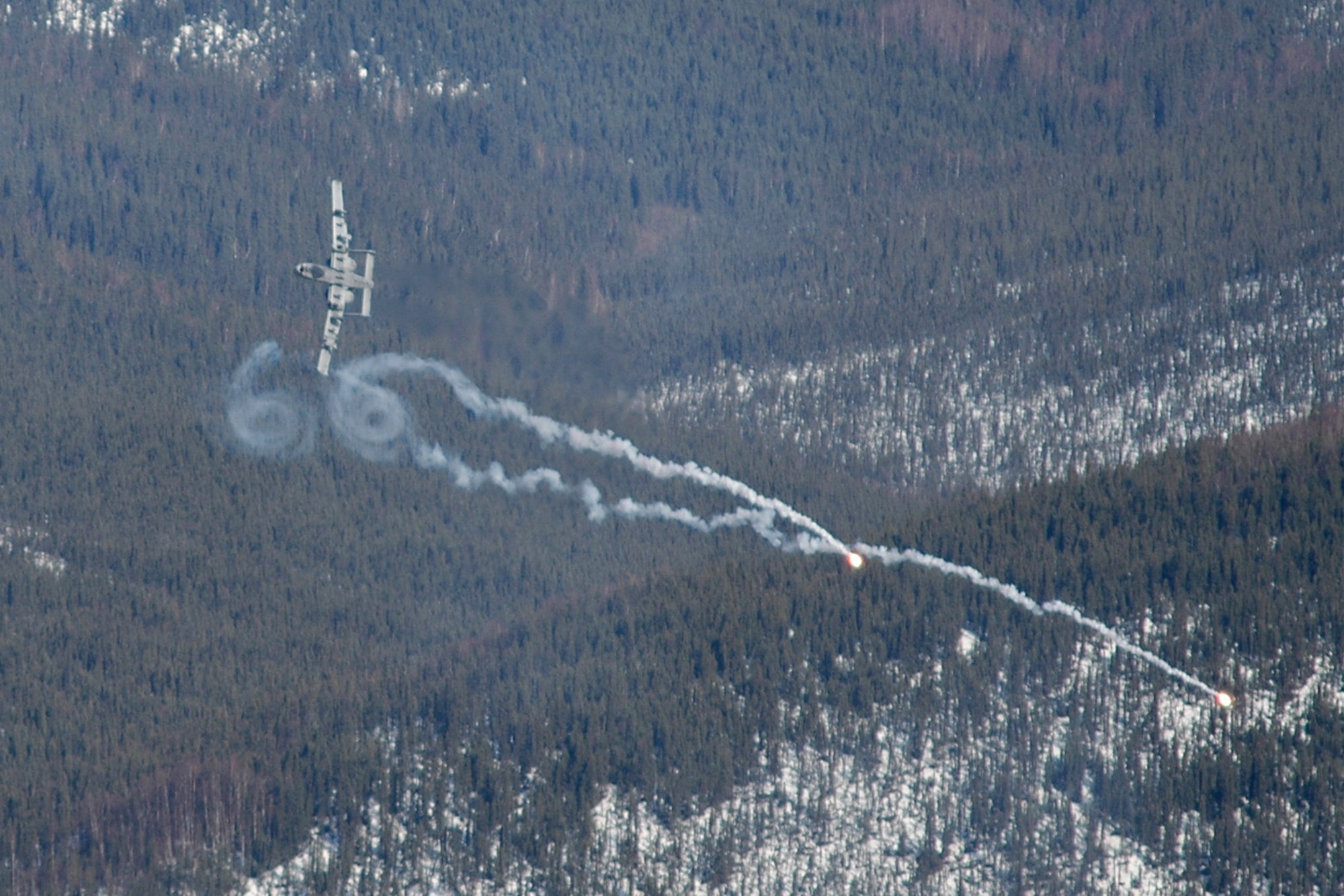 EIELSON AIR FORCE BASE, Alaska - An A-10 Thunderbolt II from the 75th Fighter Squadron, Pope Air Force Base, N.C., pops flares and pulls out of a dive at the bombing range here April 28, 2006, after strafing a mock "hostile" convoy during RED FLAG - Alaska 06-2. Joint Terminal Attack Controllers from the 25th Air Support Operations Squadron, Hickam AFB, Hawaii, called in close air support and directed planes to their targets as part of the training exercise. (Air Force Photo by Tech. Sgt. Jeff Walston)