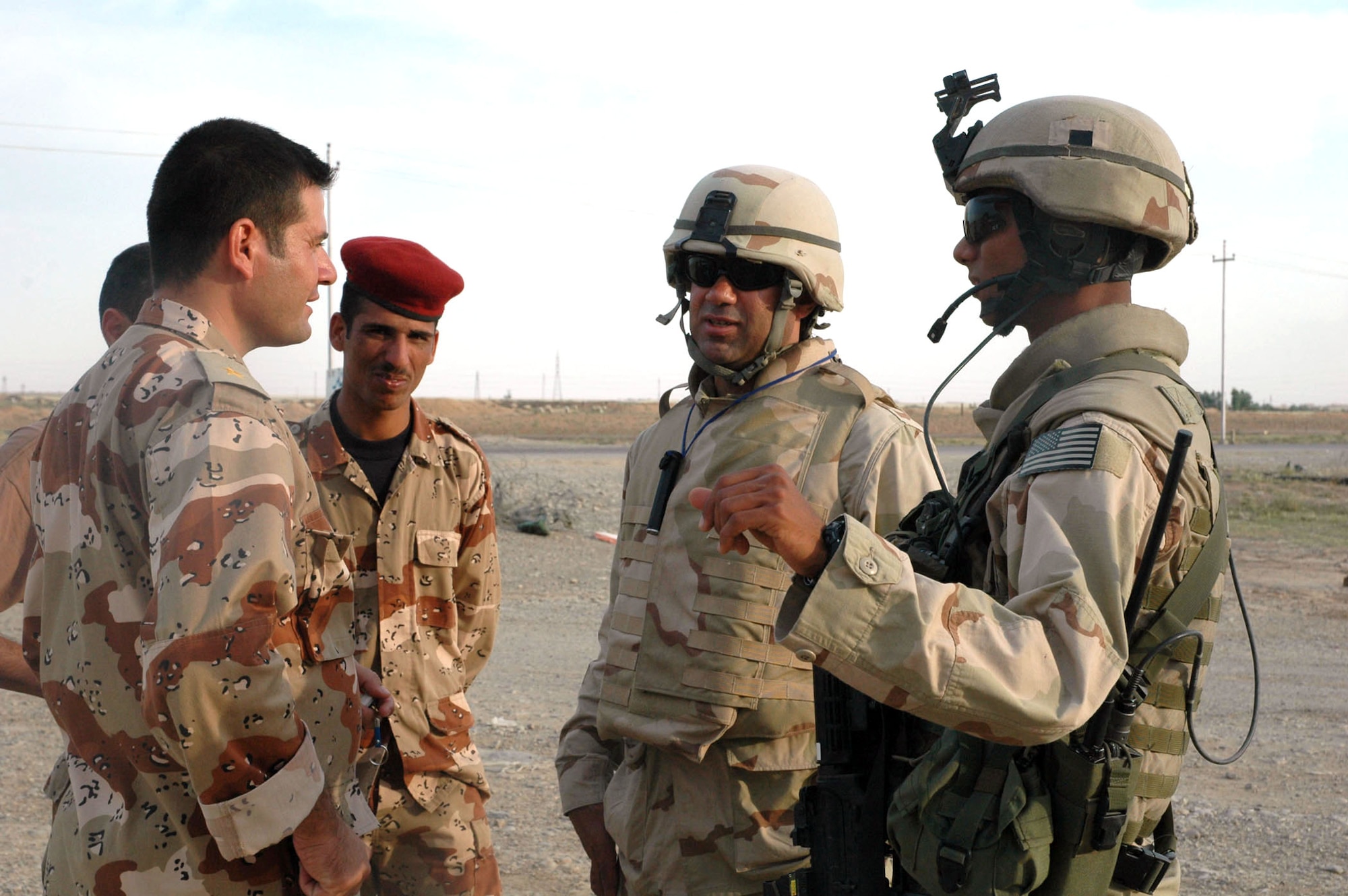 First Lt. Justin Banez (right) checks in with an Iraqi lieutenant through Ayob Hajibadri, an interpreter, at a traffic checkpoint near the city of Kirkuk, Iraq, on Monday, May 22, 2006. Airmen of the 506th Expeditionary Security Forces Squadron conduct patrols in the base defense zone of Kirkuk. Lieutenant Banez is deployed from Moody Air Force Base, Ga. (U.S. Air Force photo/Staff Sgt. Kristina Barrett)