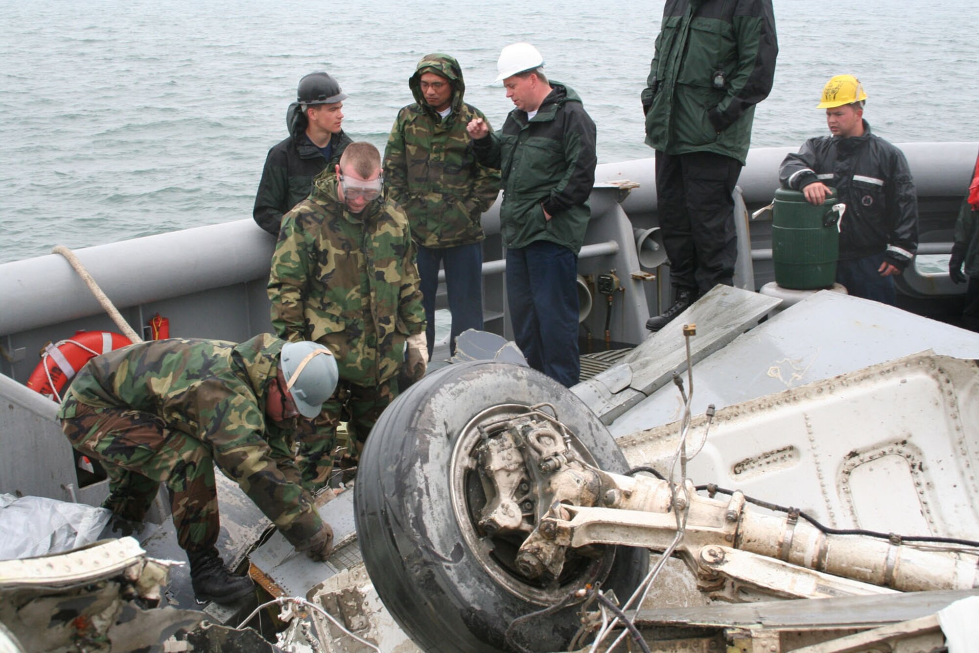 IN THE WEST SEA, Republic of Korea ? Staff Sgt. Ryan Aday (far left), crash recovery, searches for a flight data recorder among F-16 wreckage salvaged by Navy divers. The wreckage from the March 14 crash was recovered by the U.S.S. Safeguard May 10 and will assist in the investigation. (Photo by Staff Sgt. Melissa Allan)