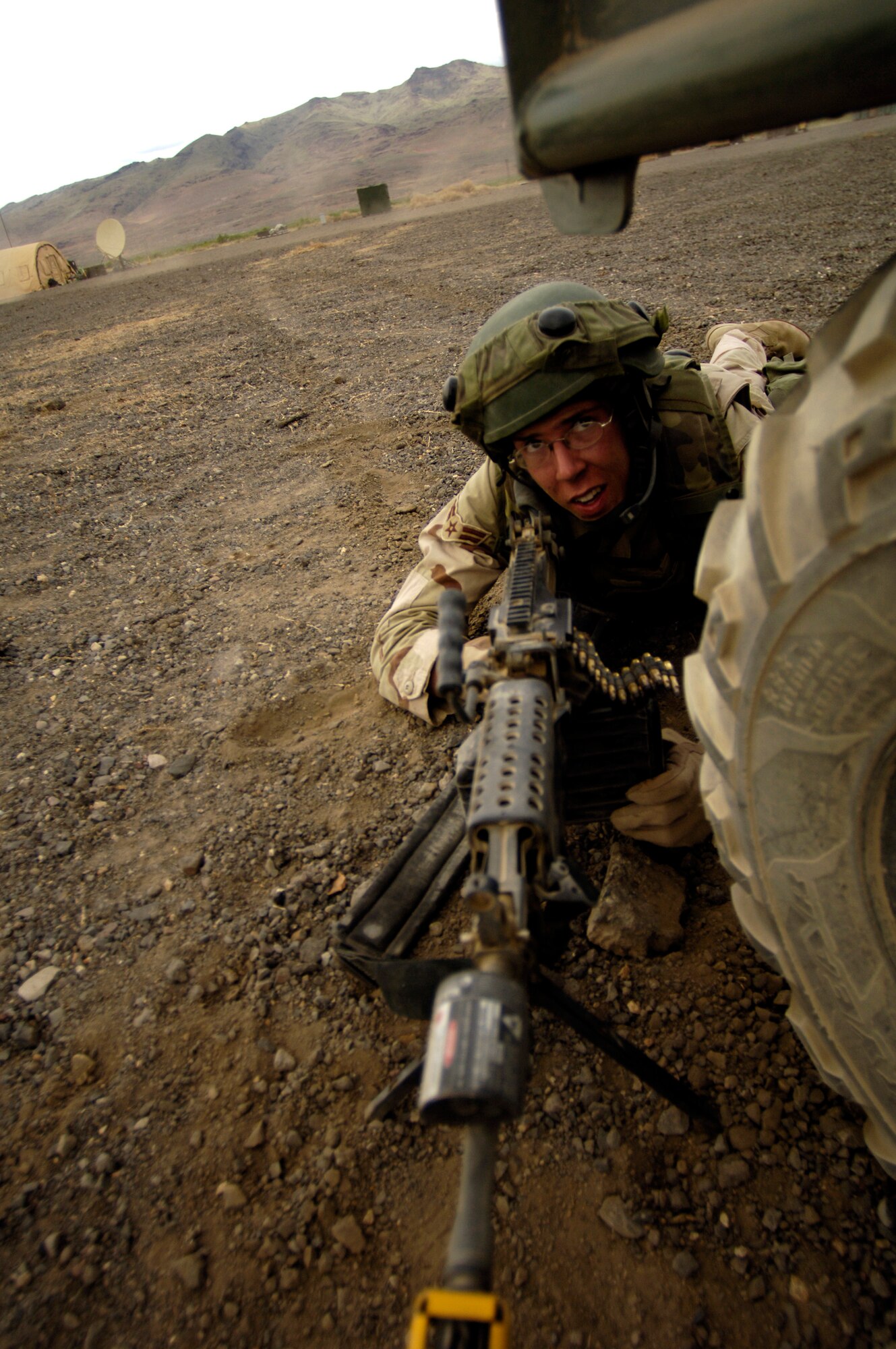 A security forces Airman takes cover behind an all-terrain vehicle during a simulated firefight as part of Lightning Fury, an airfield seizure exercise at Amedee Field in Herlong, Calif., on Saturday, May 20, 2006. (U.S. Air Force photo/Staff Sgt. James L. Harper Jr.) 