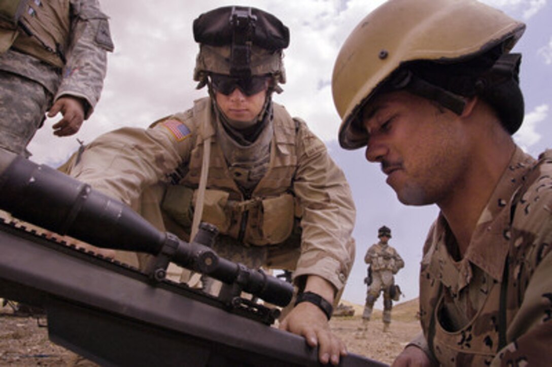 U.S. Army Spc. Michael Florczykowski (center) instructs an Iraqi army soldier on the use of a Barrett M-107 sniper rifle during joint weapons training in Tall Afar, Iraq, on May 18, 2006. Florczykowski is attached to the 1st Brigade Combat Team, 1st Armored Division. 