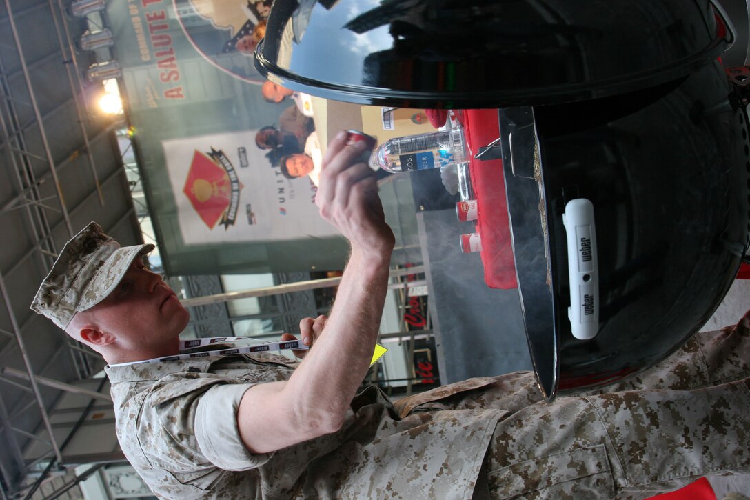 Command of the Grill competitor Sgt. Michael Clawson, Marine Corps Mobilization Command Kansas City, Mo., put the final touch of seasoning on his sirloins, as the row of judges looked on in the background.