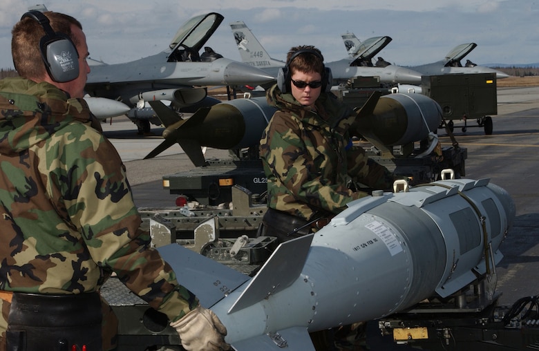 EIELSON AIR FORCE BASE, Alaska - Master Sergeant Dorian Gatchell and Senior Airman Ashley Buus from the Air National Guard's 175th Fighter Squadron at Sioux Falls, S.D. prepare to load bombs onto an F-16 Fighting Falcon.  The bombs will be dropped over the Pacific Alaska Range Complex during Red Flag - Alaska 06-2. More than 1,500 active duty, Reserve and Air National Guard Airmen, 84 Aircraft and an Army and Navy unit are participating from both Eielson and Elmendorf Air Force Base. (US Air Force Photo by TSgt Julie Avey)                             