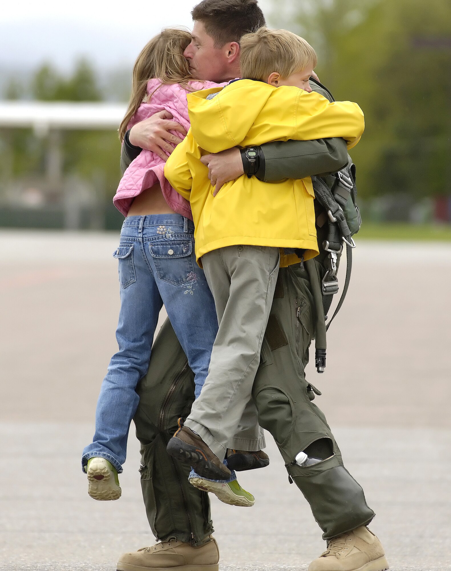 Lt. Col. Hank Harder hugs his 8-year-old daughter, Haley, and 6-year-old son, Henry, after returning from Iraq on Monday, May 22, 2006. Colonel Harder is an F-16 Fighting Falcon pilot with the Vermont Air National Guard's 134th Fighter Squadron. He and other "Green Mountain Boys" had deployed in support of Operation Iraqi Freedom. (Air National Guard photo/Master Sgt. Rob Trubia) 

