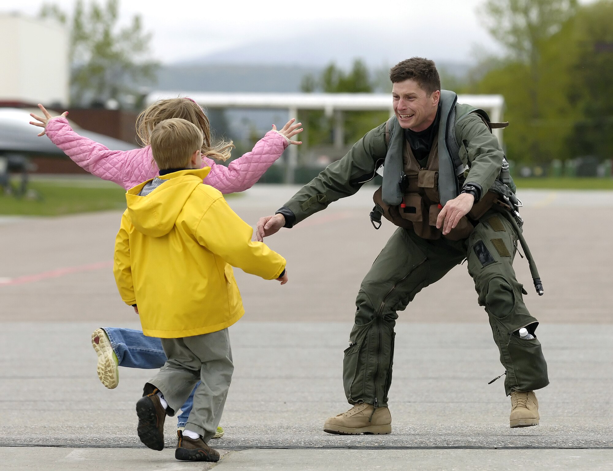Lt. Col. Hank Harder reaches out to hug his 8-year-old daughter, Haley, and 6-year-old son, Henry,  upon returning from Iraq on Monday, May 22, 2006. Colonel Harder is an F-16 Fighting Falcon pilot with the Vermont Air National Guard's 134th Fighter Squadron. He and other "Green Mountain Boys" had deployed in support of Operation Iraqi Freedom. (Air National Guard photo/Master Sgt. Rob Trubia) 

