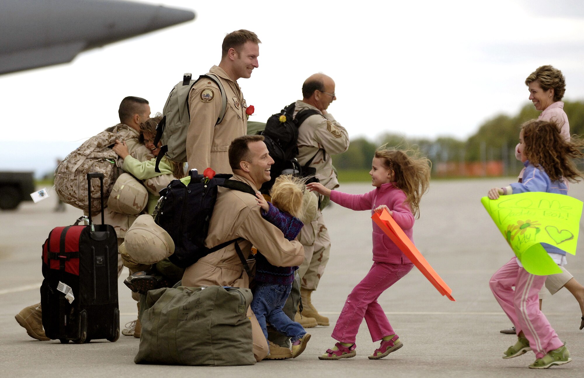 Lt. Col. Robert  Ammon embraces his 2-year-old daughter, Jessica, while 5-year-old Casey and 7-year-old Megan follow quickly behind in South Burlington, Vt., on Monday, May 22, 2006. Colonel Ammon is with the Vermont Air National Guard's 158th Fighter Wing. He and other "Green Mountain Boys" had deployed in support of Operation Iraqi Freedom. (Air National Guard photo/Master Sgt. Rob Trubia)
