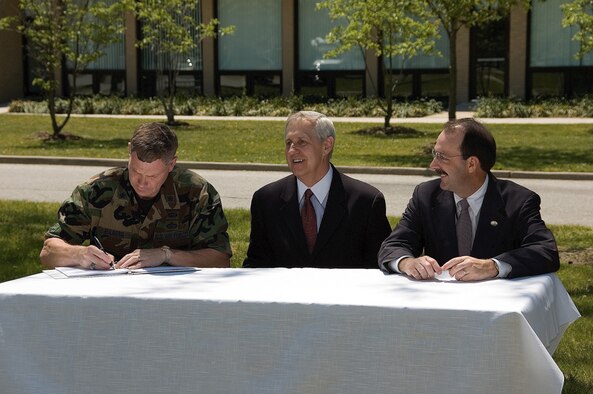 (Left to right) Brig. Gen. Del Eulberg, Air Mobility Command director of Installations and Mission Support, signs the record of decision for two contaminant release sites along with William Wisniewski, Environmental Protection Agency deputy regional administrator, and James Werner, Delaware Department of Natural Resources and Environmental Control director of Air and Waste Management, here May 12. (U.S. Air Force photo by Roland Balik)