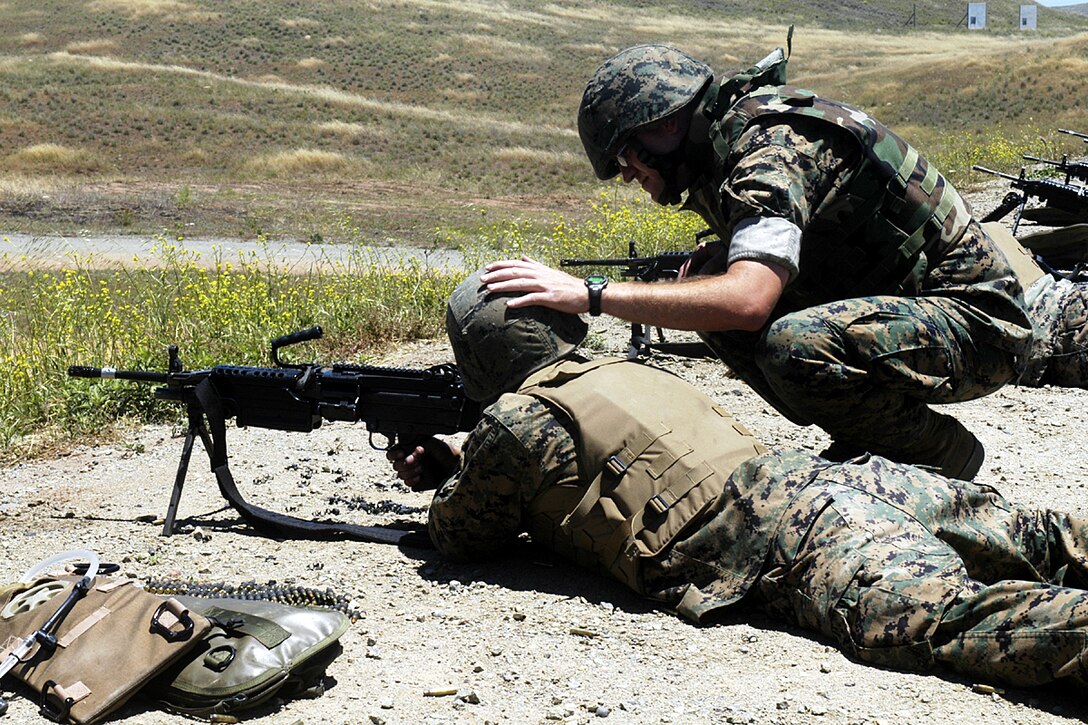 Camp Pendleton, Calif. - Staff Sgt. Darrin Minderman, a nculear, biological and chemical specialist with the 15th Marine Expeditionary Unit, provides extra assitance to a Marine from the 15th MEU during a recent Squad Automatic Rifle course. The course was given to Marines from the Command Element of the 15th MEU in an effort to prepare them for duty as SAW-gunners while a member of a security element. (Official USMC photo by Staff Sgt. T.G. Kessler) (Released)