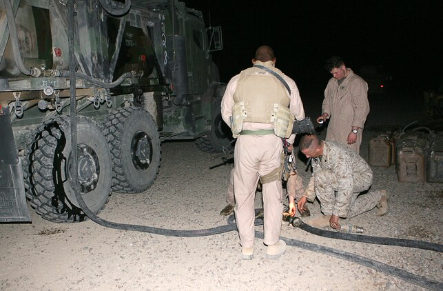 After working on the connecting pieces of a hose, Marines with Combat Logistics Company 115 were able to successfully refill a fuel bladder May 24, 2006 at an outpost on the edges of Fallujah. The company, along with the rest of Combat Logistics Battalion 5, serves as a logistical support unit in the Al Anbar Province, supporting American and Iraqi forces operating here. On major re-supply convoys, such as this one CLC 115 will deliver food, water, fuel and other equipment or supplies to multiple locations in one trip outside the security of Camp Fallujah.