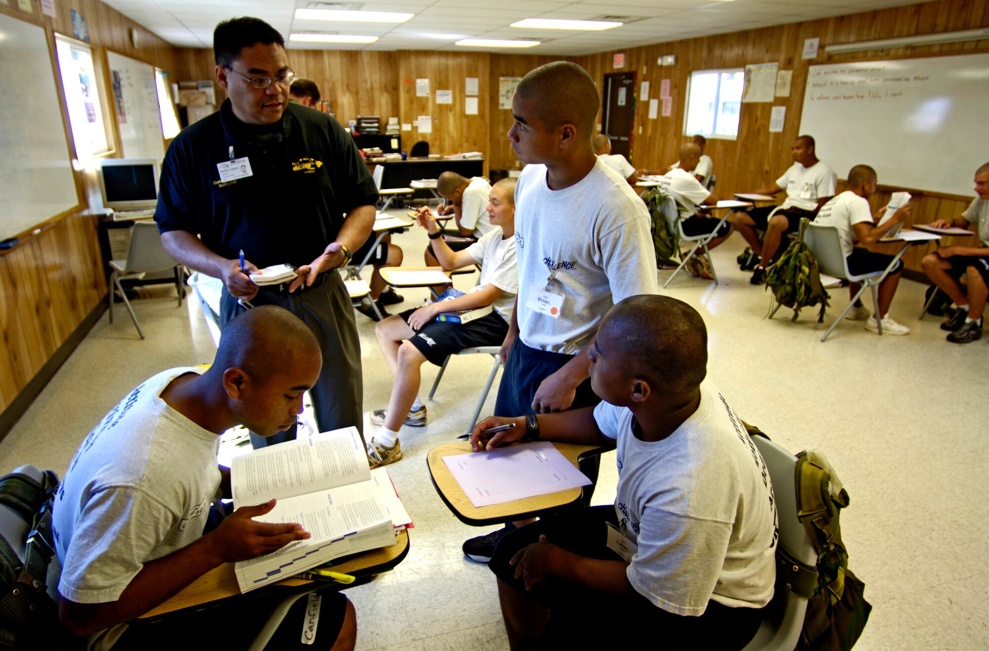 Dwayne Barcial helps students with questions on Thursday, May 18, 2006, as they study for their general equivalency diploma at the Hawaii National Guard Youth Challenge Academy in Kapolei, Hawaii. Mr. Barcial is the academy writing teacher.  The academy staff teach life skills to non-traditional students so they can be successful in the community and earn a high school diploma.  (U.S. Air Force photo/Tech. Sgt. Shane A. Cuomo)