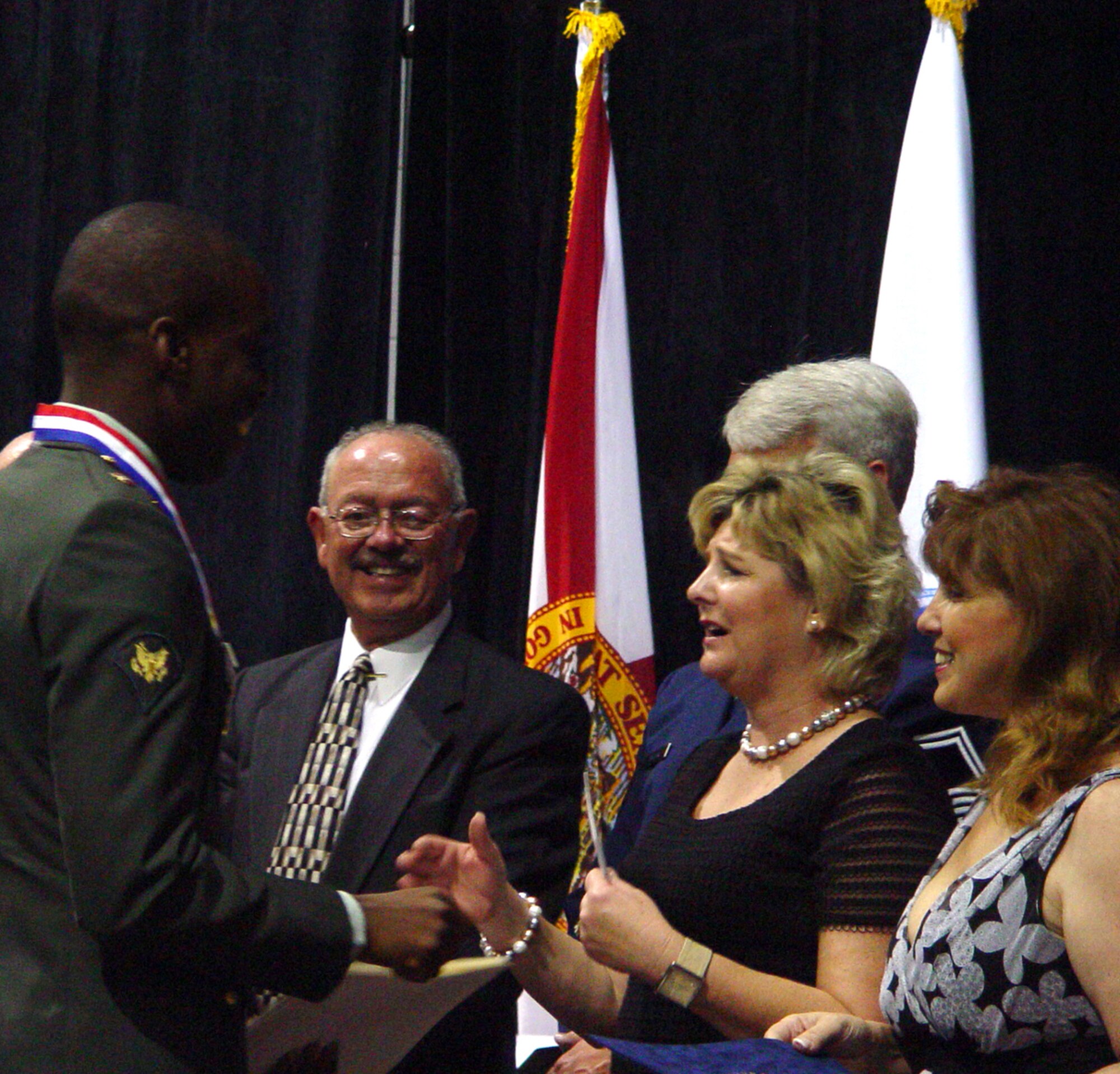 Specialist Paul Jolomi Agbeyegbe, 50th Area Support Group Soldier of the Year, receives an award from Sue Newman, Homestead/Florida City Military Affairs Committee.  (Air Force photo by Lisa Macias)