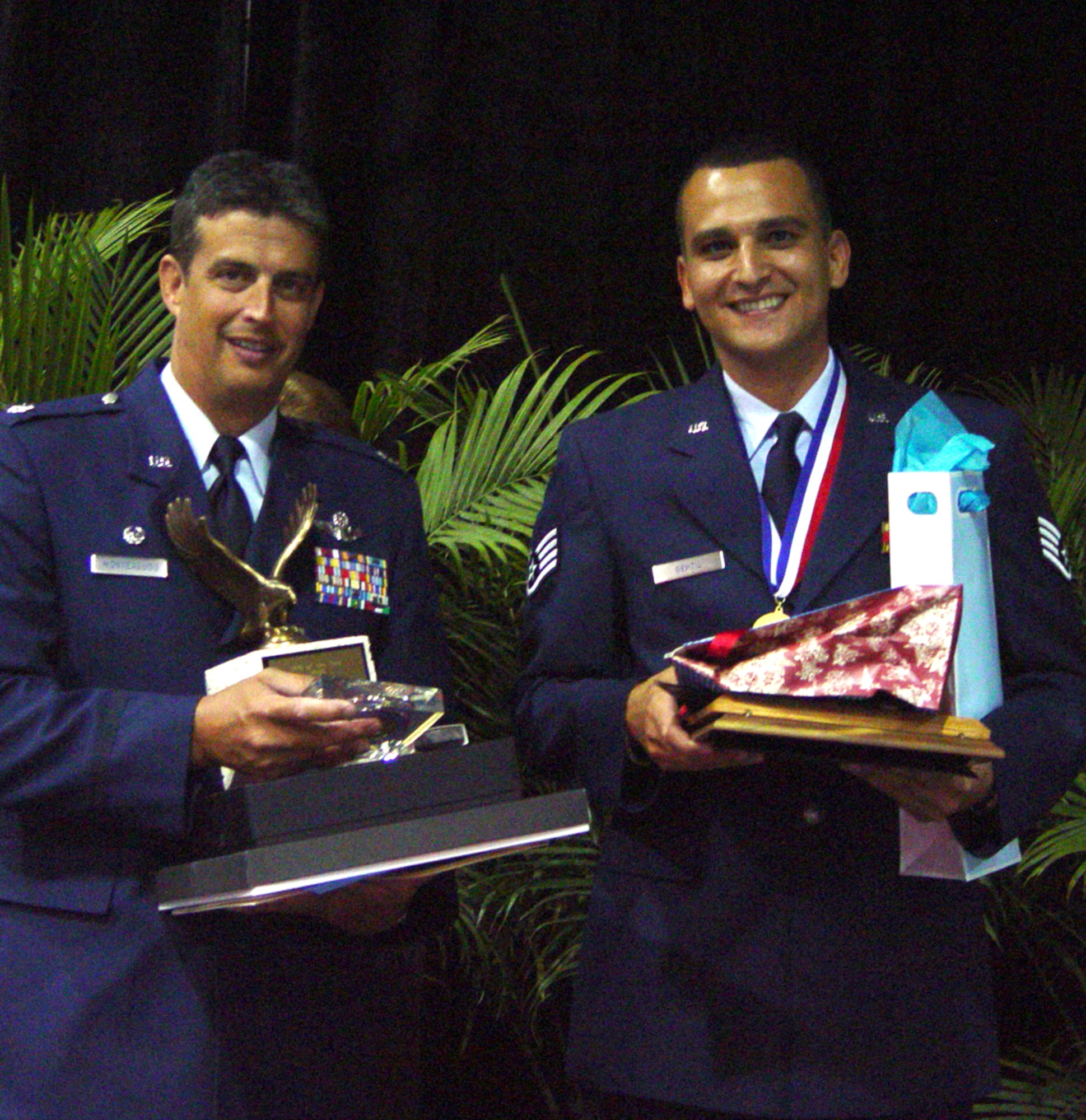 Staff Sgt Edouard Gentil, 482nd Fighter Wing NCO of the Year, enlisted the help of Lt. Col. Jose Monteagudo to carry all the awards he received during the banquet. (Air Force photo by Lisa Macias)           