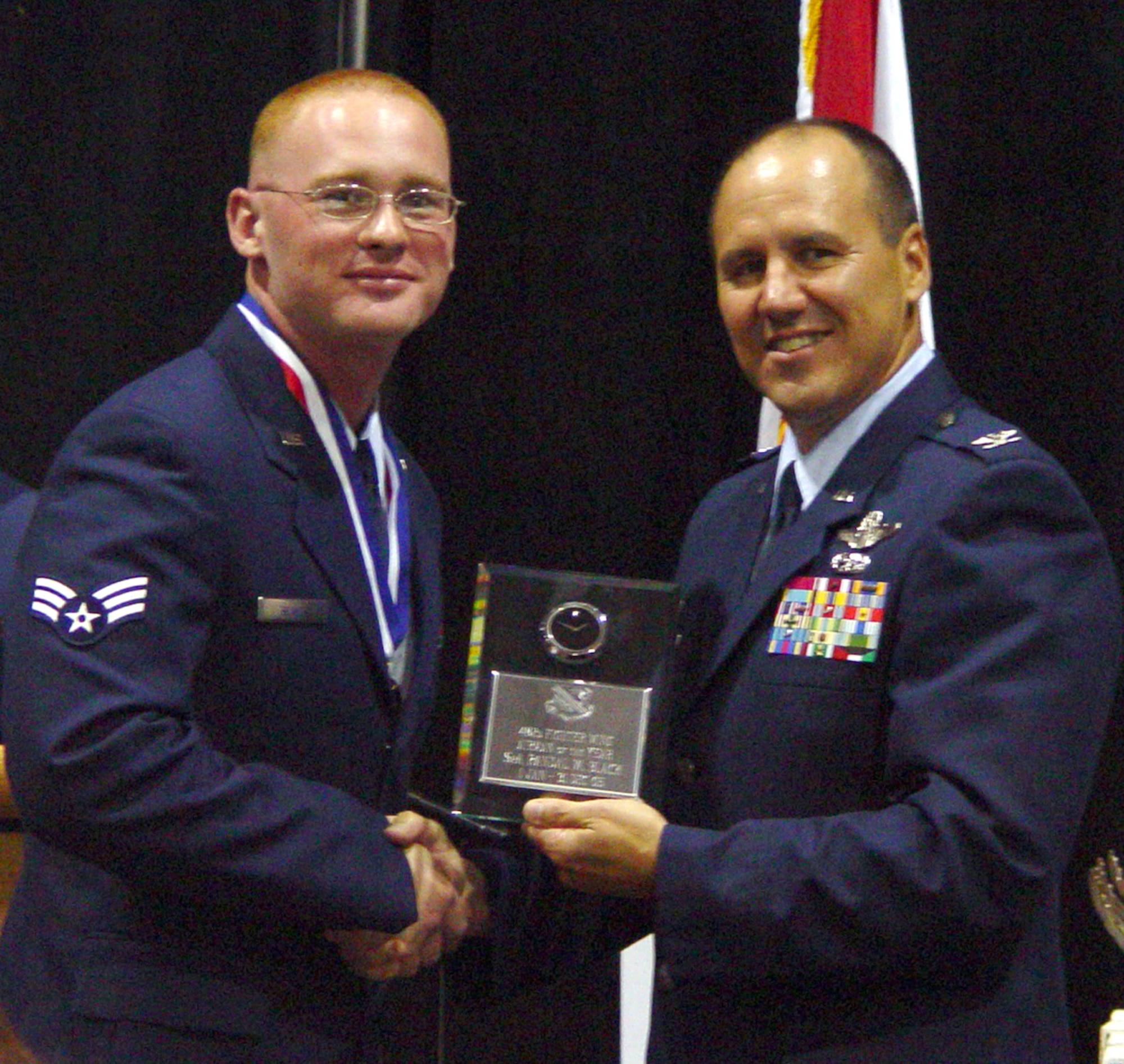 Senior Airman Randal Black, 482nd Fighter Wing Airman of the Year, receives an award from Col Randy Falcon, 482nd Fighter Wing Commander.  (Air Force photo by Lisa Macias)