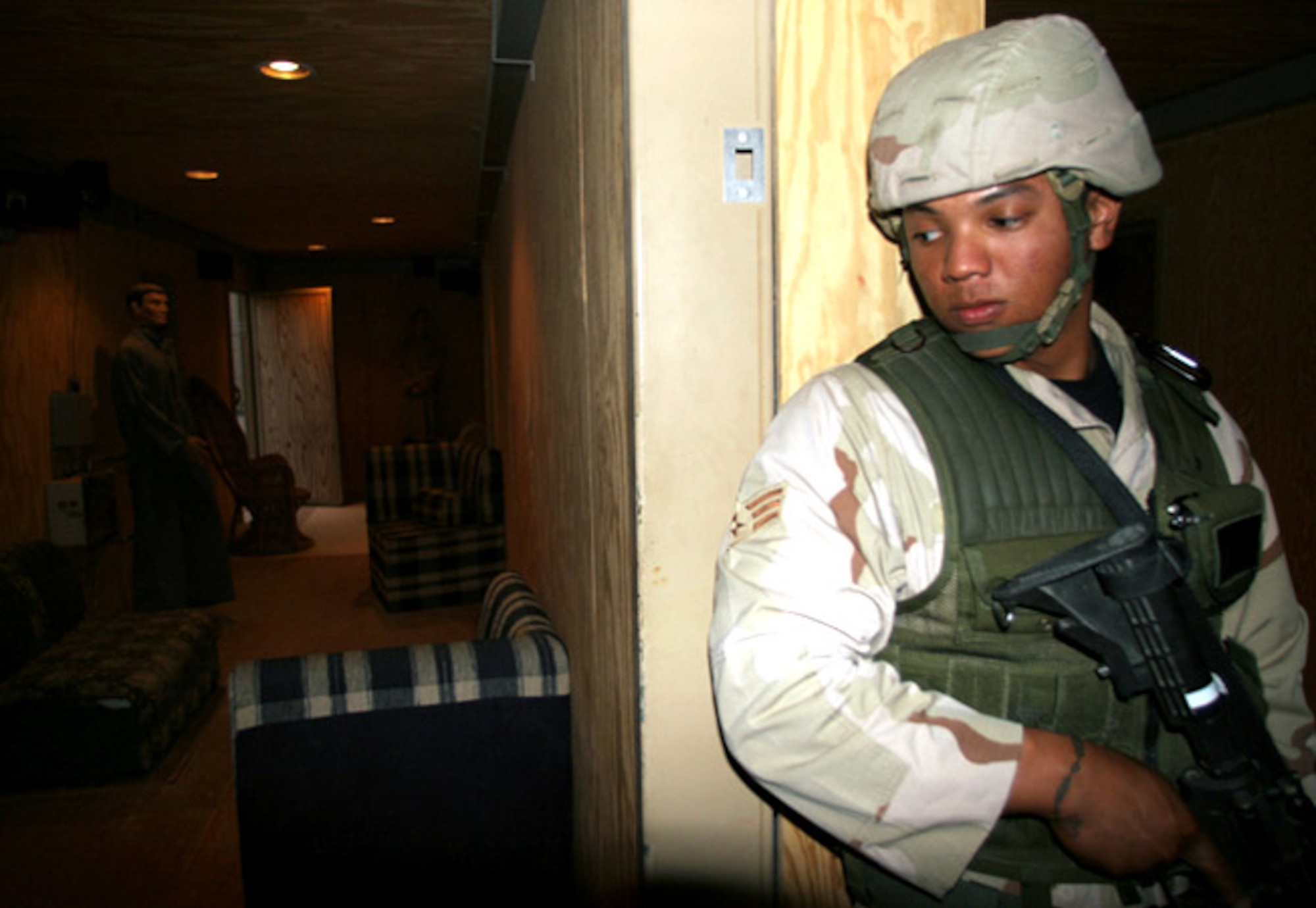 Senior Airman Paris Carman checks around the doorway of a simulated Iraqi home during "military operations in urban terrain" training on Friday, May 19, 2006, in Southwest Asia. (U.S. Army photo)

