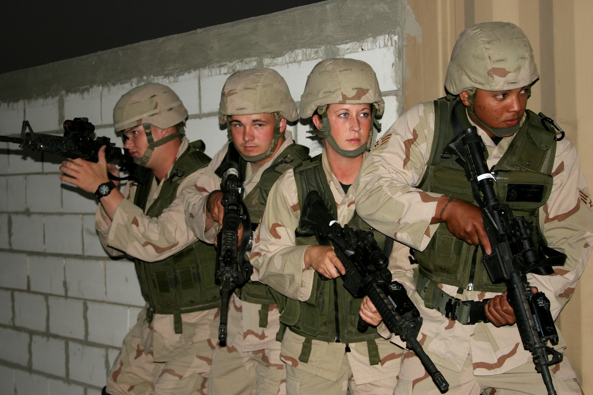 (From left) Senior Airman Christopher Blair, Airman 1st Class Kendal Hudson and Senior Airmen Ravin Coulon and Paris Carman prepare to move into a building during "military operations in urban terrain" training on Friday, May 19, 2006, in Southwest Asia. (U.S. Army photo)

