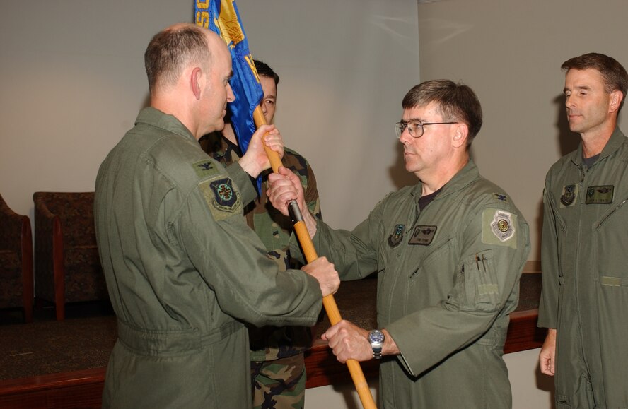 Col. Tom Yanni (center holding flag) assumes command of the Air Force Special Operations Command Air and Space Operations Center, or AOC, from Col. Rick Leibach (right) during a change of command ceremony recently. About a year ago, the AOC was established to directly support AFSOC's warfighting capability. "This ceremony celebrates the accomplishments of Colonel Leibach and welcomes, with high expectations, Colonel Yanni," said officiating officer Col. Michael Callan (left), Air Force Special Operations Forces commander. Colonel Yanni previously served as AFSOC Chief of Safety. Colonel Leibach is now assigned as AFSOC Operations Chief of Standardization and Evaluation. (U.S. Air Force photo by A1C Ali Flisek)