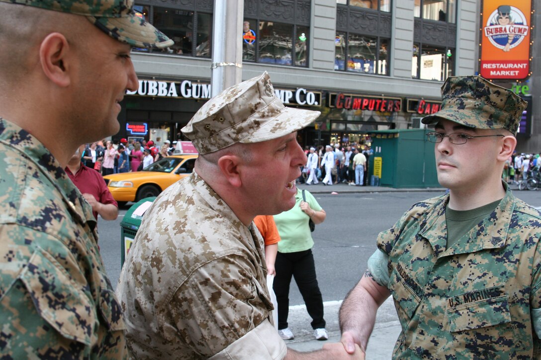 GySgt. Alex Kitsakos, a Marine reservist and New York police officer shakes the hand of newly promoted Sgt. Jose A. Maldonada. Kitsakos watched Maldonado grow from a young child and influenced his choice to become a Marine.
