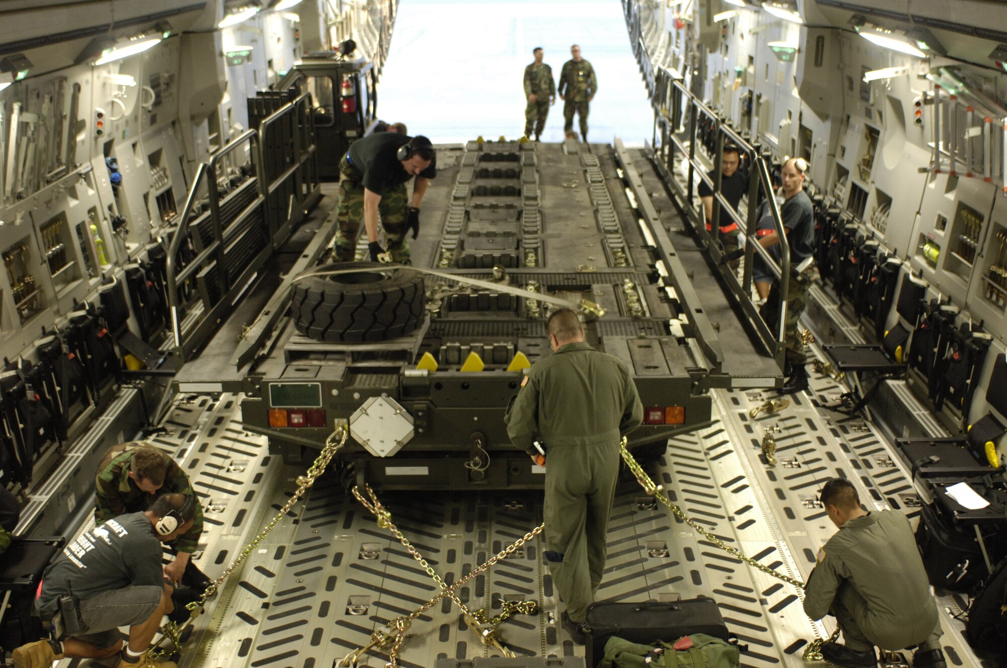 HICKAM AIR FORCE BASE, HAWAII -- Aircrew members and aerial port specialists  secure a Halvorsen aircraft pallet loader in a C-17 at Hickam Air Force Base, Hawaii, May 25.  Hickam sent the loaders along with two C-17s and approximately 25 personnel to assist the Australian Defense Force move personnel and equipment to Australia from the Solomon Islands in support of peace operations in East Timor after continued unrest between East Timorese military forces and breakaway groups of police and military. (U.S. Air Force Photo by Tech. Sgt. Shane Cuomo)  