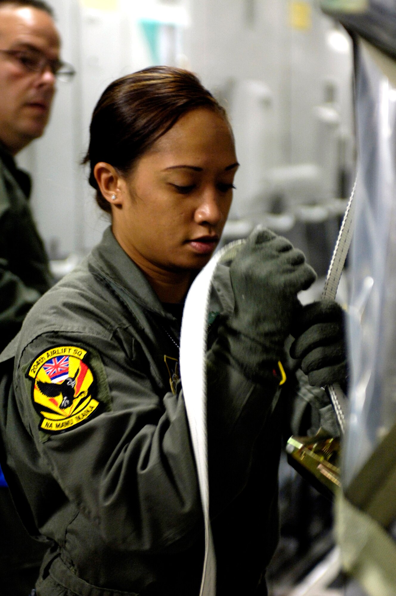 Staff Sgt. Joleen Manuia tightens a cargo strap on an equipment pallet on a C-17 Globemaster III at Royal Australian Air Force Base Townsville, Australia, on Sunday, May 28, 2006. Sergeant Manuia is a C-17 Globemaster III loadmaster with the Hawaii Air National Guard's 204th Airlift Squadron.  She is one of the Air Force crew members helping move equipment and troops from the Solomon Islands to Australia, repositioning Australian Defense Forces to support peace operations in East Timor. (U.S. Air Force photo/Tech. Sgt. Shane A. Cuomo) 