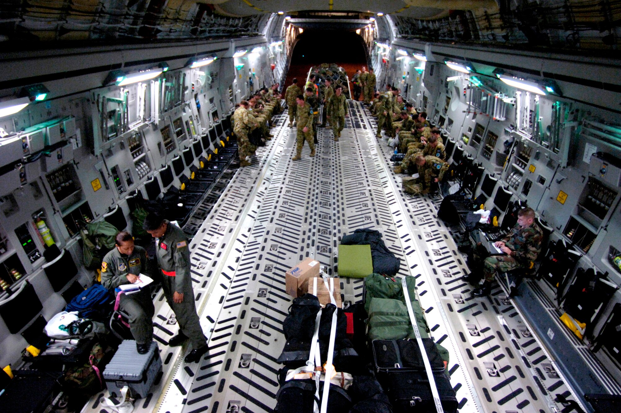 Staff Sgt. Joleen Manuia and Airman James Ngo (bottom left) look over their checklist as Australian Defense Force members load items on a C-17 Globemaster III at Honiara International Airport, Solomon Islands, on Saturday, May 27, 2006. Sergeant Manuia is with the Hawaii Air National Guard's 204th Airlift Squadron. Airman Ngo is with the 535th AS at Hickam. Both are C-17 Globemaster III loadmasters. They are two of the Air Force crew members helping move equipment and troops from the Solomon Islands to Australia, repositioning Australian Defense Forces to support peace operations in East Timor. (U.S. Air Force photo/Tech. Sgt. Shane A. Cuomo)