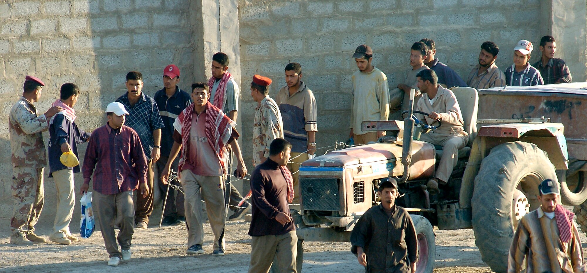 Workers line up to enter Ar Rasheed Base, Iraq, on Friday, May 26, 2006. The Iraqi soldiers search every person and every vehicle that enters. Each soldier is trained and advised by five security forces Airmen and their Army commander who live and work on the base. (U.S. Air Force photo/Senior Airman Brian Ferguson)

