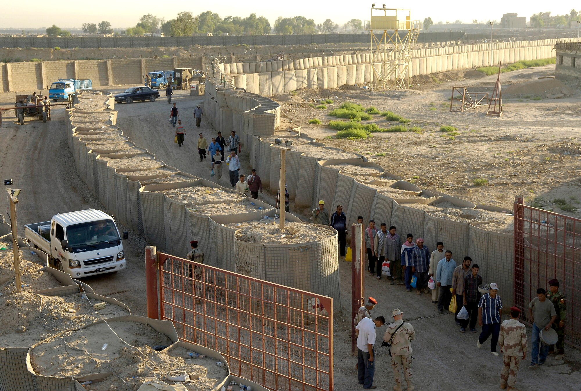 Workers line up to enter Ar Rasheed Base, Iraq, on Friday, May 26, 2006. Hundreds of workers enter the base daily. The soldiers search every person and vehicle that enters. Each soldier is trained and advised by five security forces Airmen and their Army commander who live and work on the base. (U.S. Air Force photo/Senior Airman Brian Ferguson)