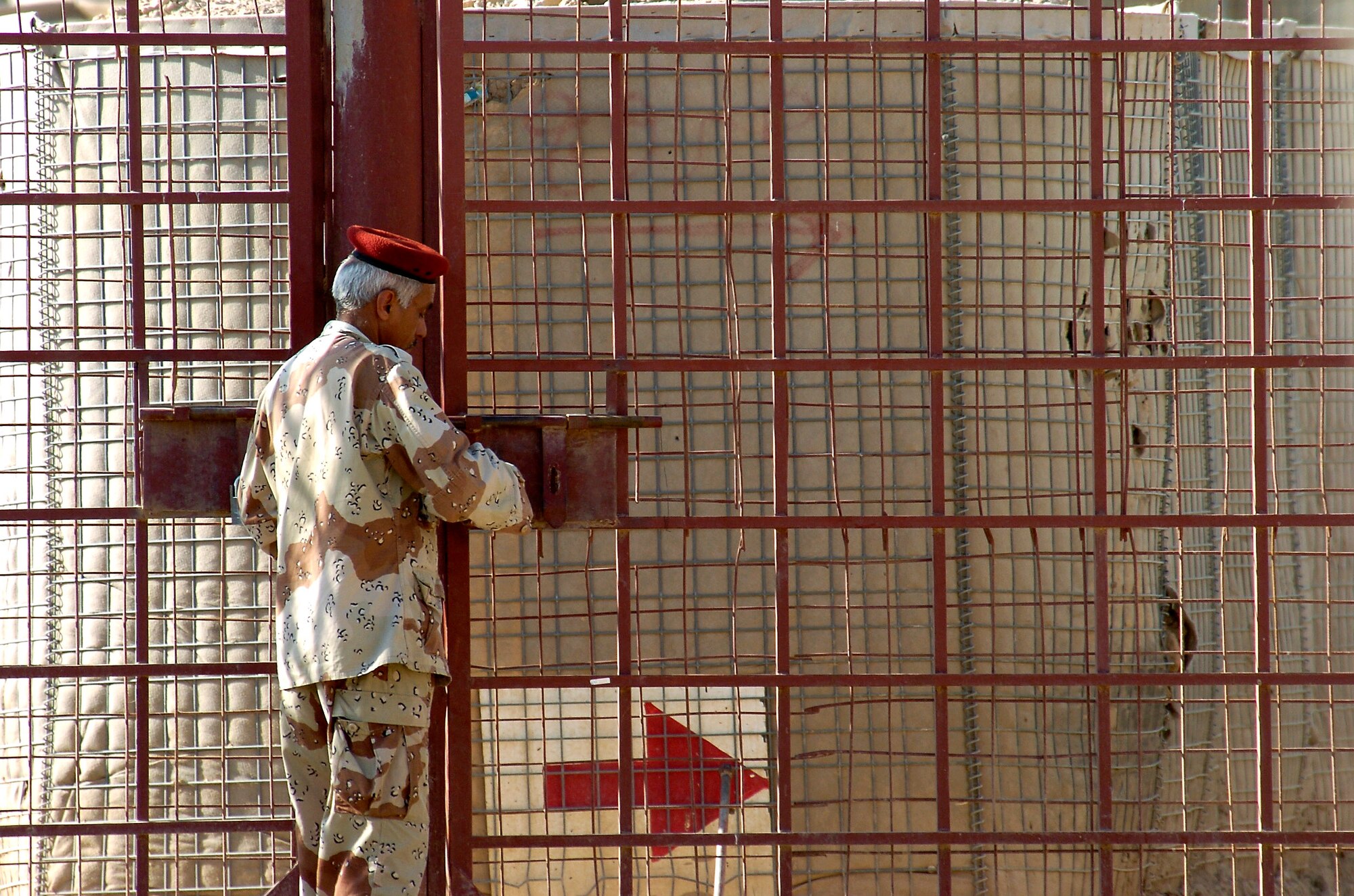 An Iraqi soldier locks the gate at Ar Rasheed Base, Iraq, on Thursday, May 25, 2006. The soldier is with the 1st Iraqi Army Division/Iraqi Intervention Forces, which provide defense for the compound. Five security forces Airmen and their Army commander live on the base and advise the Iraqi Army on base defense procedures. (U.S. Air Force photo/Senior Airman Brian Ferguson)
