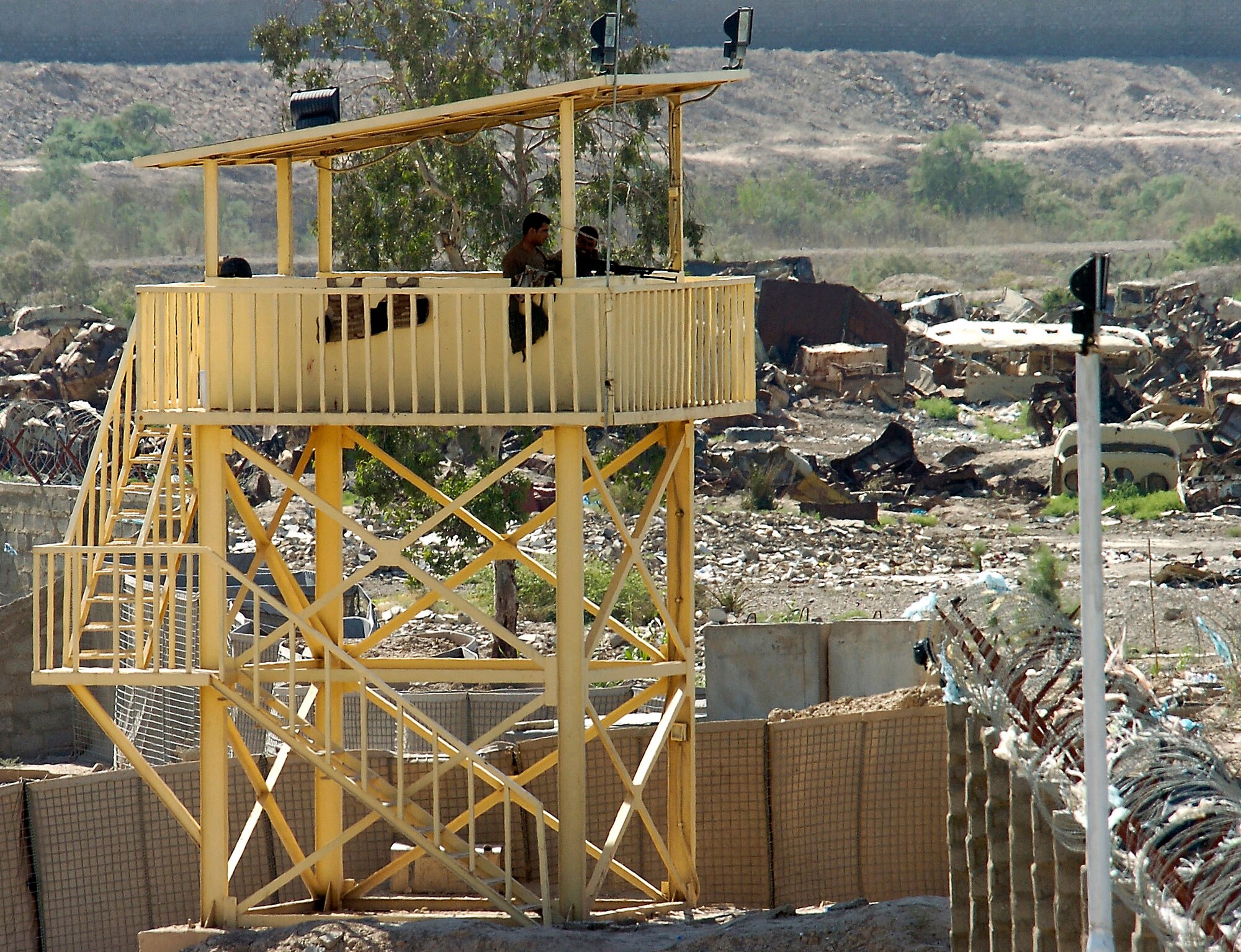 Two Iraqi soldiers look for suspicious activity outside the walls of Ar Rasheed Base, Iraq, on Thursday, May 25, 2006. The soldiers are with the 1st Iraqi Army Division/Iraqi Intervention Forces, which provides the base defense for the compound. Five security forces Airmen and their Army commander live on the base and advise the Iraqi Army on base defense procedures. (U.S. Air Force photo/Senior Airman Brian Ferguson)