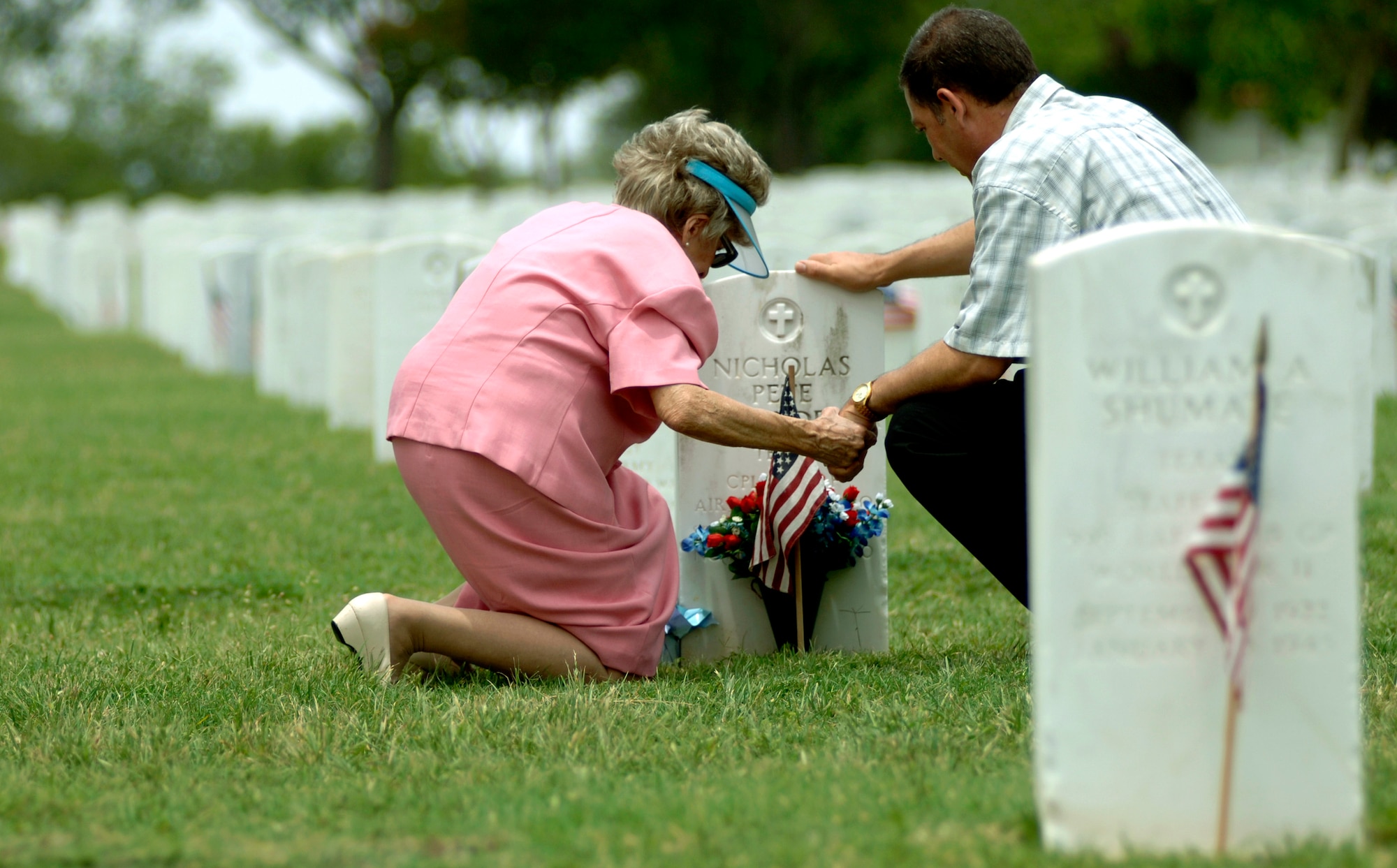 Mary Royalty and her son, David, hold hands and pray at her father's grave site at Fort Sam Houston National Cemetery in San Antonio on Sunday, May 28, 2006. Members of her family, who immigrated from Greece, have served in the U.S. military since before World War I. (U.S. Air Force photo/Tech. Sgt. Cecilio Ricardo)
