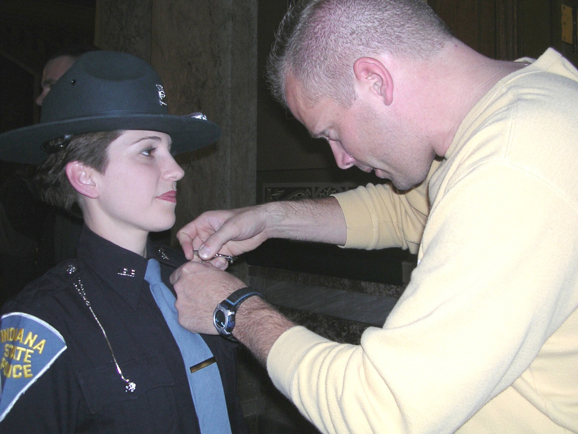 Tech. Sgt. Jerry Cummings pins on a state trooper's badge onto his wife Senior Airman, and new Indiana State Police Trooper, Vicki Cummings.  She is an information management apprentice with the 72nd Air Refueling Squadron at Grissom Air Reserve Base, Ind.  (Photo provided)