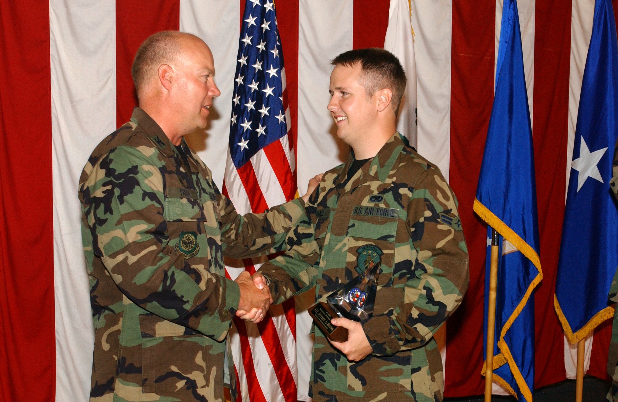 Col. Keith Frede, 60th Maintenance Group commander, presents Airman 1st Class Jeffrey Bruns with the Knucklebuster Award May 22. The peer-presented Knucklebuster Awards are given to Airmen who go the extra mile. While their co-workers pick the Knucklebusters, Colonel Frede picks the top Knucklebuster award winner. Airman Bruns was picked out of a pool of more than 70 people. (U.S. Air Force photo by Nan Wylie)
