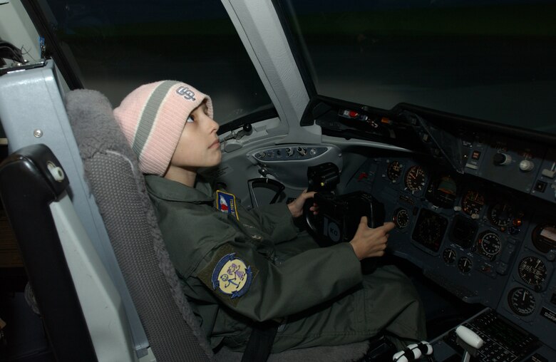 Katie Powell, 10,  daughter of Master Sgt. Chris Powell, 60th Operations Group, flies a KC-10 simulator during her time as Pilot for a Day. (U.S. Air Force photo by Andre Mansour)
