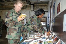 Second Lt. Robin Frailer, a military equal opportunity officer with the 433rd Airlift Wing (right), and Master Sgt. Theresa Cauley, first sergeant for the wing staff, pick through the one dollar book sale at the Family Support Office. The books were new donated by the 37th FSO to help fund family support programs in the wing.