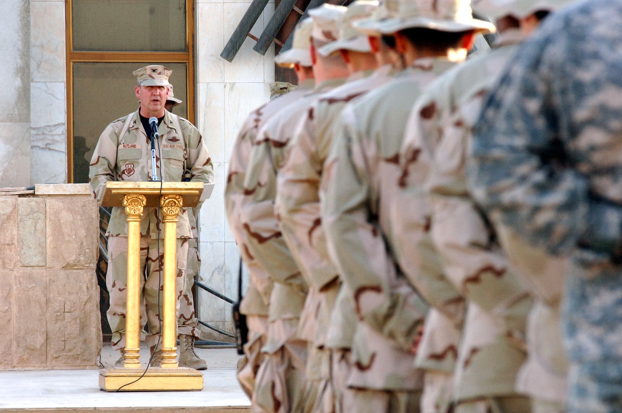 Col. Ron Rutland addresses Airmen and Soldiers at a Memorial Day retreat ceremony at Sather Air Base, Iraq, on Monday, May 29, 2006. The colonel, deployed from Dover Air Force Base, Del., is the 447th Air Expeditionary Group commander. The 447th AEG operates the primary aerial port for transient military aircraft entering and exiting Iraq. The base is named in honor of Staff Sgt. Scott Sather, a Clio, Mich., native who was killed in combat in Iraq on April 8, 2003. (U.S. Air Force photo/Staff Sgt. Bryan Bouchard)