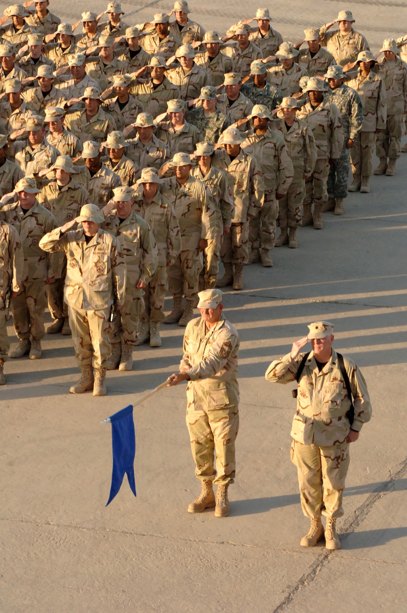 Airmen and Soldiers render salutes at the 447th Air Expeditionary Group's Memorial Day retreat ceremony at Sather Air Base, Iraq, on Monday, May 29, 2006. The 447th AEG operates the primary aerial port for transient military aircraft entering and exiting Iraq. The base is named in honor of Staff Sgt. Scott Sather, a Clio, Mich., native who was killed in combat in Iraq on April 8, 2003. (U.S. Air Force photo/Staff Sgt. Bryan Bouchard)