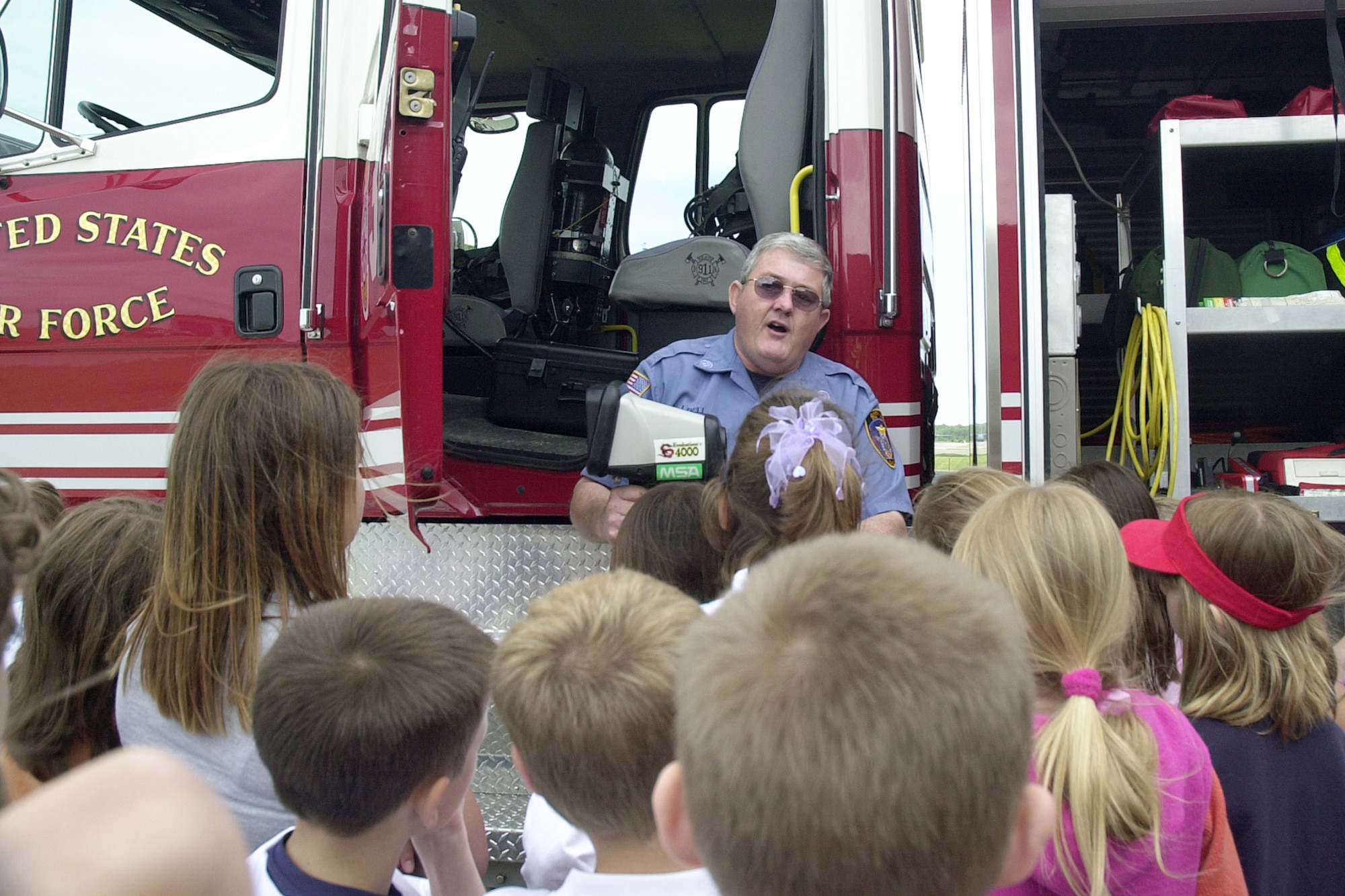 YOUNGSTOWN AIR RESERVE STATION, Ohio - Mr. Jeffery L. Bell, a civilian fire fighter employed with the 910th Airlift Wing here, discusses a thermal imaging camera with third-graders from Lowellville K-12 School in Lowellville, Ohio.  The children are just some of the more than 1,000 people who can be expected to tour Youngstown Air Reserve Station during the May to September tour season. (U.S. Air Force photo/Tech. Sgt. Ken Sloat)                                