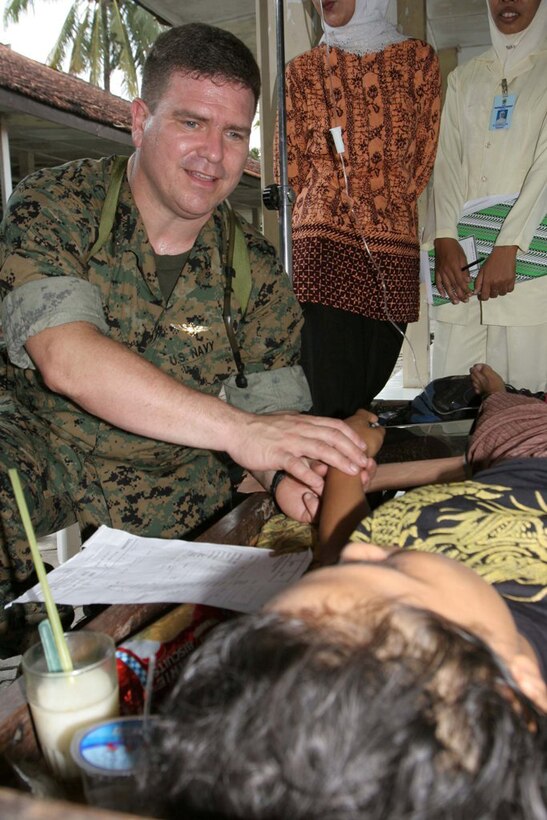BANTUL, Indonesia ? Lt. Cmdr. Carlos Godinez checks the pulse of Siti Nuriyami, in Bantul, Indonesia, May 31 after a 6.2 magnitude earthquake struck the island of Java. Nuriyami suffered broken ribs and a arm during the earthquake. Godinez is a III Marine Expeditionary Force surgeon. (Official U.S. Marine Corps photo by Lance Cpl. Warren Peace)