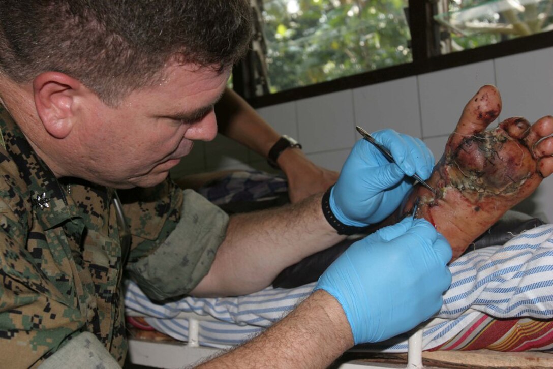BANTUL, Indonesia ? Lt. Cmdr. Carlos Godinez operates on the foot of in Indonesian man in Bantul, Indonesia, May 31 after a 6.2 magnitude earthquake struck the island of Java. Godinez is a III Marine Expeditionary Force surgeon. (Official U.S. Marine Corps photo by Lance Cpl. Warren Peace)