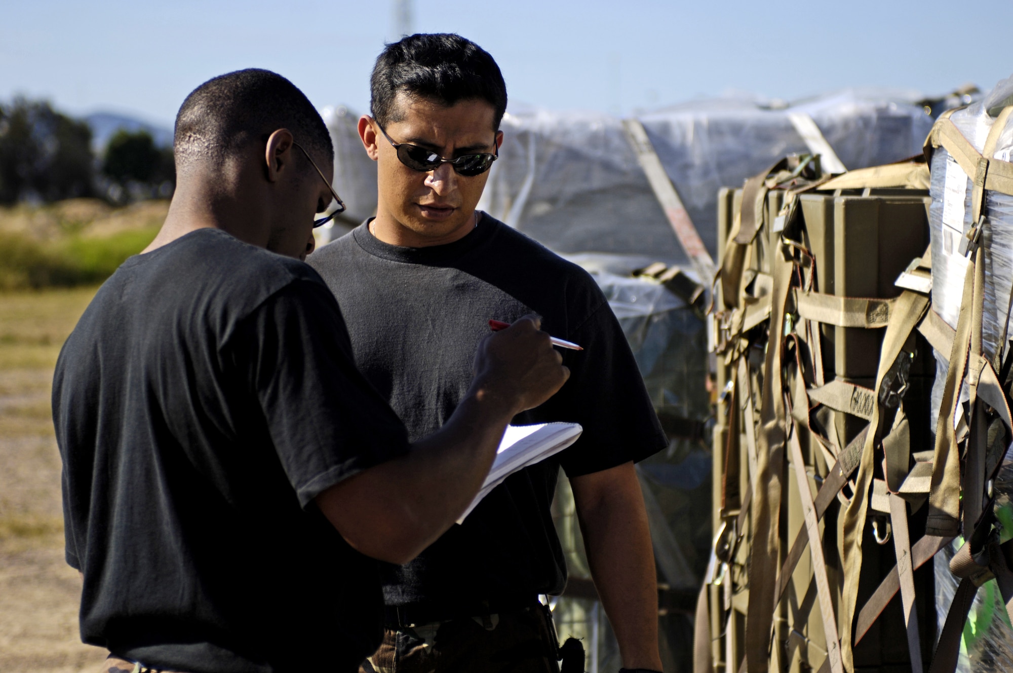 060530-F-2034C-002
Staff Sgt. Oscar Merritt and Tech. Sgt. Guillermo Hernandez look over weights and measurements for Australian equipment pallets May 30, 2006 at Royal Australian Air Force Base Townsville, Australia. Sgt.s Merritt and Hernandez are from the 15th Logistical Readiness Squadron, Combat Mobility Element. The CME is in Townsville to help prepare and load equipment on C-17 Globemaster III from Hickam Air Force Base, Hawaii that are repositioning Australian Defense Forces inside Australia to better support peace operations in East Timor. (U.S. Air Force photo by Tech. Sgt. Shane A. Cuomo) 
