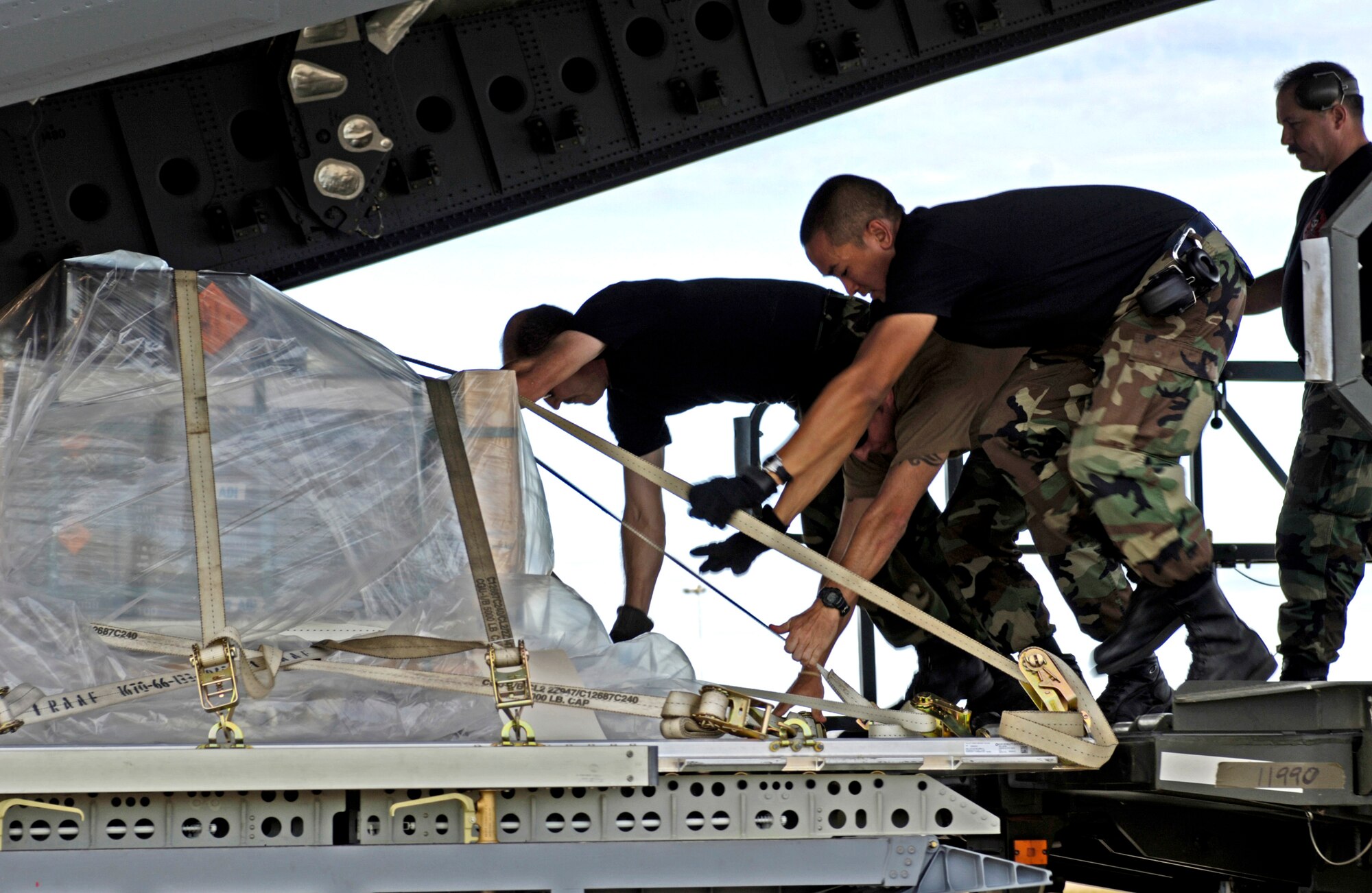 Airmen from the Combat Mobility Element, or CME, push a cargo pallet onto a C-17 Globemaster III at Royal Australian Air Force Base Townsville, Australia, on Tuesday, May 30, 2006. The CME is part of the 15th Logistical Readiness Squadron at Hickam Air Force Base, Hawaii. The CME is in Townsville to help prepare and load equipment on C-17s from Hickam that are repositioning Australian Defense Forces to better support peace operations in East Timor. (U.S. Air Force photo/Tech. Sgt. Shane A. Cuomo) 