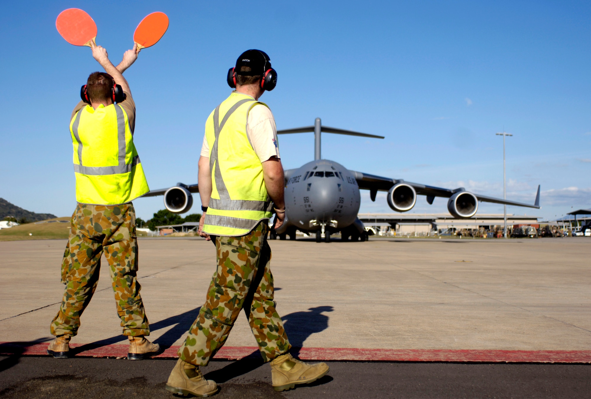 Members of the Australian Air Force marshal a C-17 Globemaster III into a parking spot at Royal Australian Air Force Base Townsville, Australia, on Tuesday, May 30, 2006. Two C-17s from the 15th Airlift Wing and the Hawaii Air National Guard's 154th Wing at Hickam Air Force Base, Hawaii, are helping the Australian Defense Force reposition its forces in Australia to better support peace operations in East Timor. (U.S. Air Force photo/Tech. Sgt. Shane A. Cuomo) 