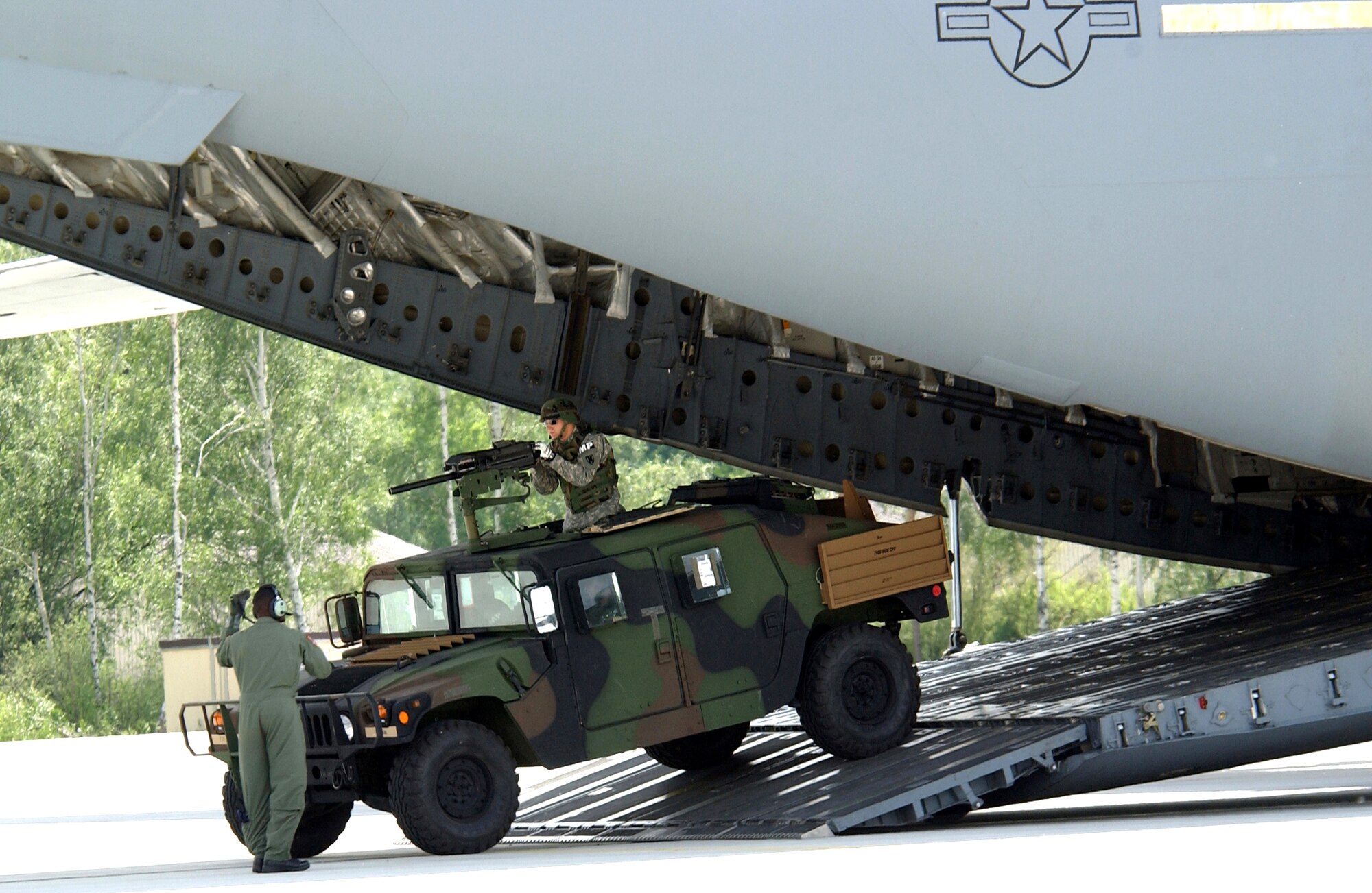 A loadmaster directs a Humvee from the 230th Military Police Company exiting a C-17 Globemaster III during Operation Vigilant Star at Ramstein Air Base, Germany, on Wednesday, May 24, 2006. The purpose of this operation was to showcase the capabilities of the C-17 to NATO countries. (U.S. Air Force photo/Senior Airman Chris Willis)