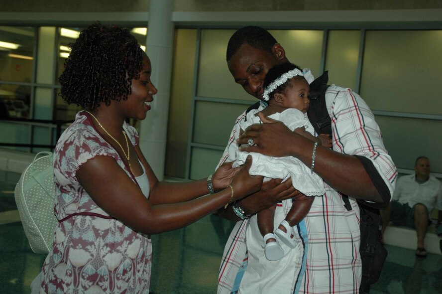 EGLIN AIR FORCE BASE, Fla. — Staff Sgt. Jason McCollough, 96th Logistics Readiness Squadron vehicle operator, meets his 2-month-old daughter, Amiyah, for the first time at the Okaloosa Regional Airport Friday with his wife, Melissa. Sergeant McCollough was deployed for more than 9 months to Kuwait. (Air Force photo by Master Sgt. Dawn Hart)