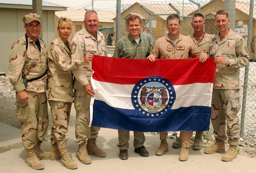 BAGRAM AIRFIELD, Afghanistan -- Governor of Missouri, Matt Blunt (civilian clothes, center), poses for photos with the Missouri state flag with members of the Air Force Reserve's 442nd Fighter Wing, Whiteman Air Force Base, Mo., May 26.  The governor toured the US Central Command area of responsibility meeting Airmen, Soldiers, Sailors and Marines from his state along the way.  With Governor Blunt are (left to right) Maj. David Kurle, Senior Master Sgt. Melissa Spawn, Chief Master Sgt. Steve Brazeal, Lt. Col. John Hoff, Senior Master Sgt. Mark Mock and Tech. Sgt. John Walton.  (Courtesy photo)