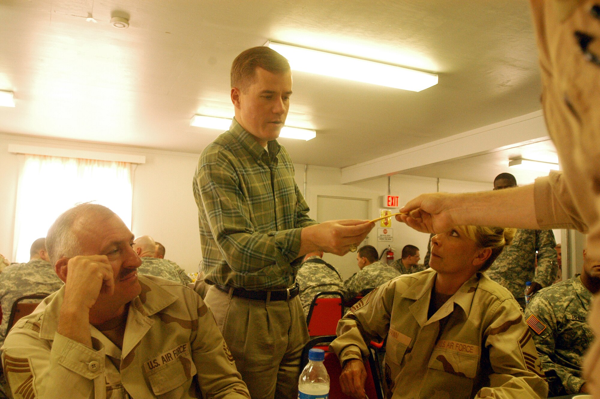 BAGRAM AIRFIELD, Afghanistan -- Missouri Governor Matt Blunt receives a 303rd Fighter Squadron patch from Lt. Col. John Hoff, a reservist deployed here from the 442nd Fighter Wing at Whiteman Air Force Base, Mo., while Chief Master Sgt. Steve Brazeal, right, and Senior Master Melissa Spawn look on.  Governor Blunt toured the US Centeral Command area of responsibillity and visited with Airmen, Soldiers, Sailors and Marines from Missouri deployed overseas.  (Photo by Maj. David Kurle)                                
