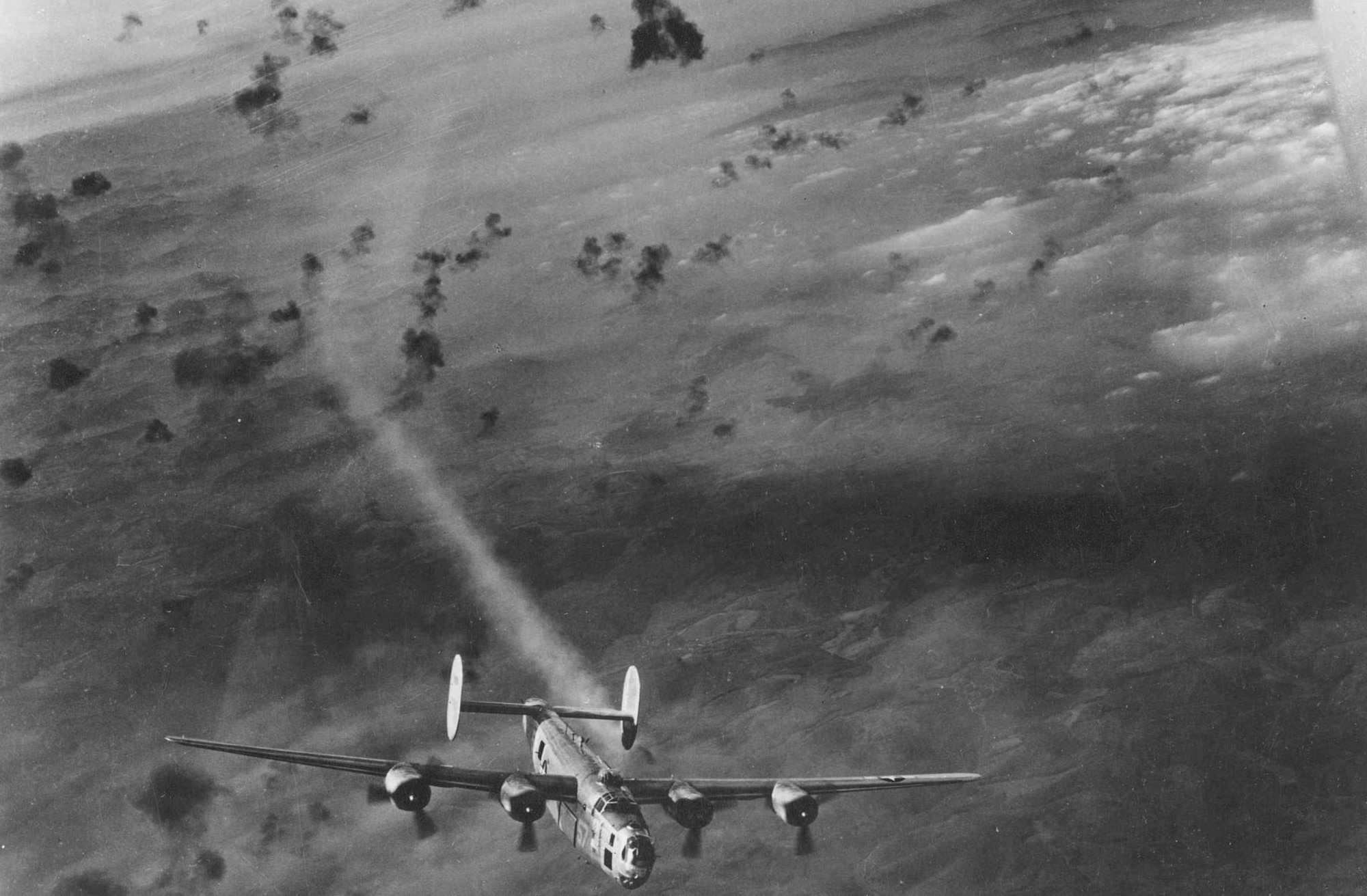 Consolidated B-24 emerges from flak area with its No. 2 engine smoking. (U.S. Air Force photo)