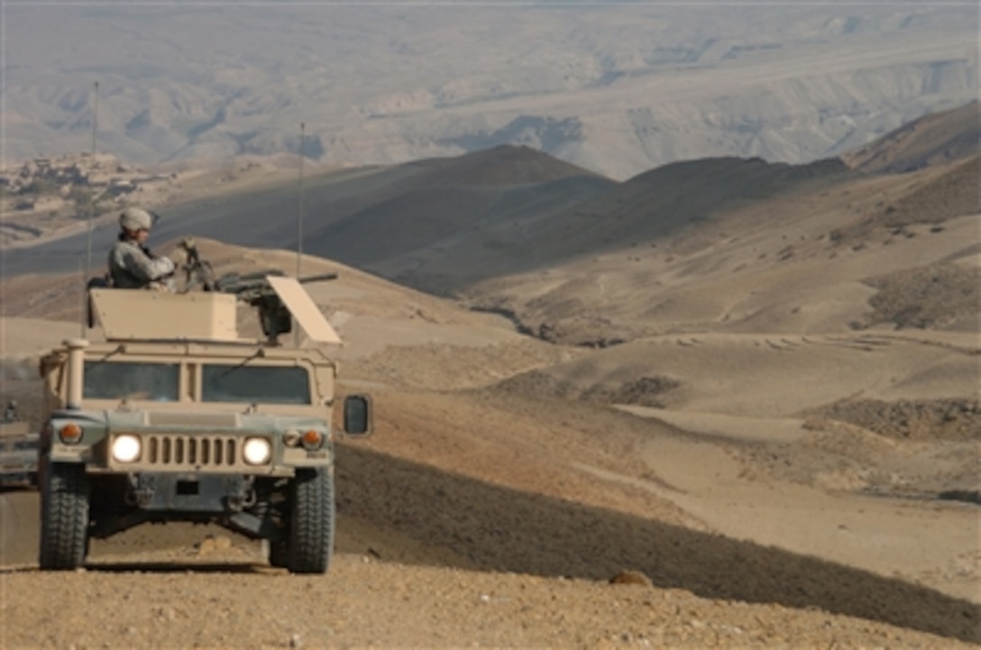 Army Pfc. Raymond Purtee watches the barren hills around him as he provides security from the gun turret of a Humvee during a patrol halt in Bagram, Afghanistan, on Oct. 27, 2006.  Purtee is with the 561st Military Police Company attached to the 10th Mountain Division.  